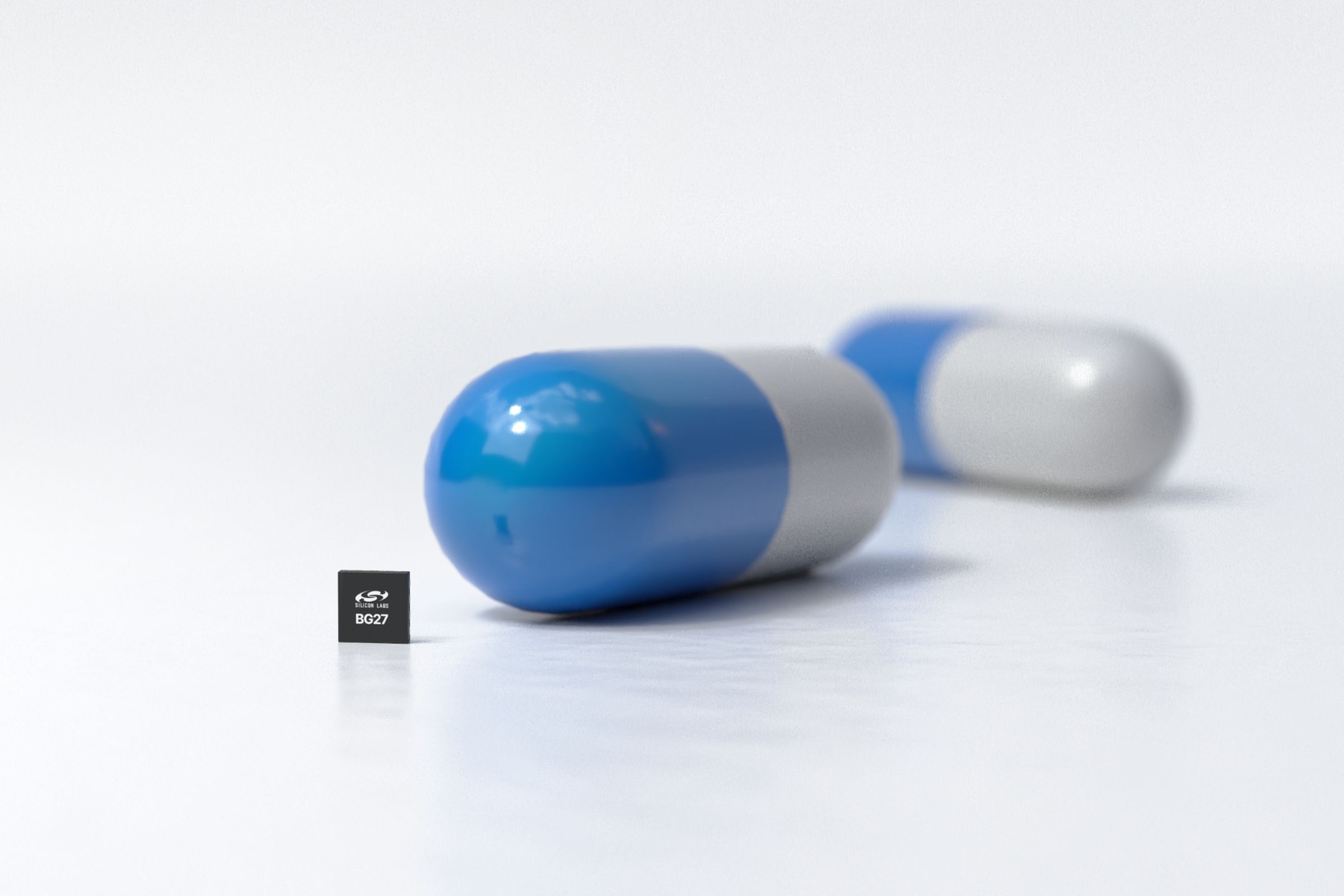 Tiny square chipset next to a seemingly giant pill capsule.