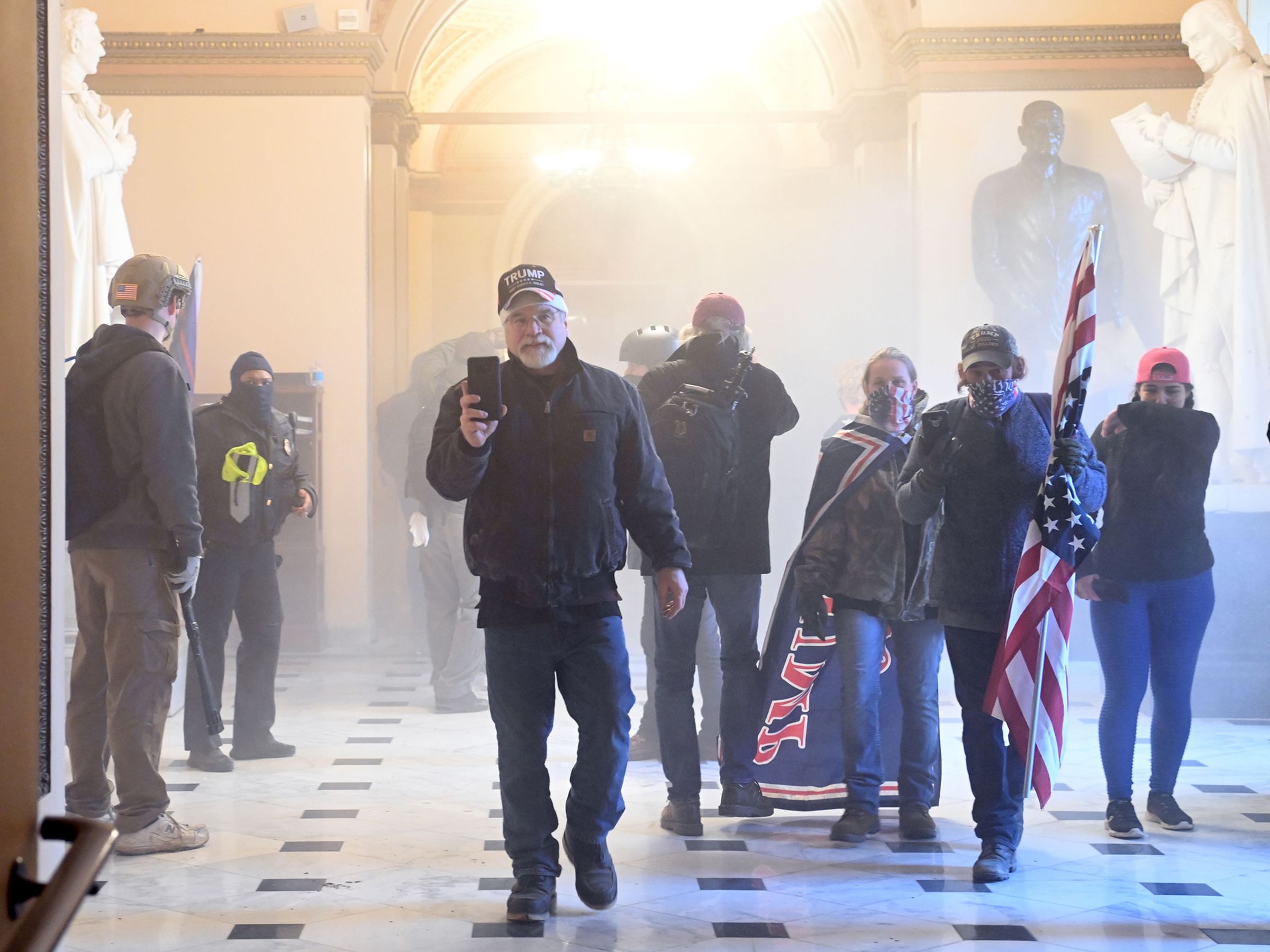 Protesters enter the US Capitol as tear gas fills the corridor.