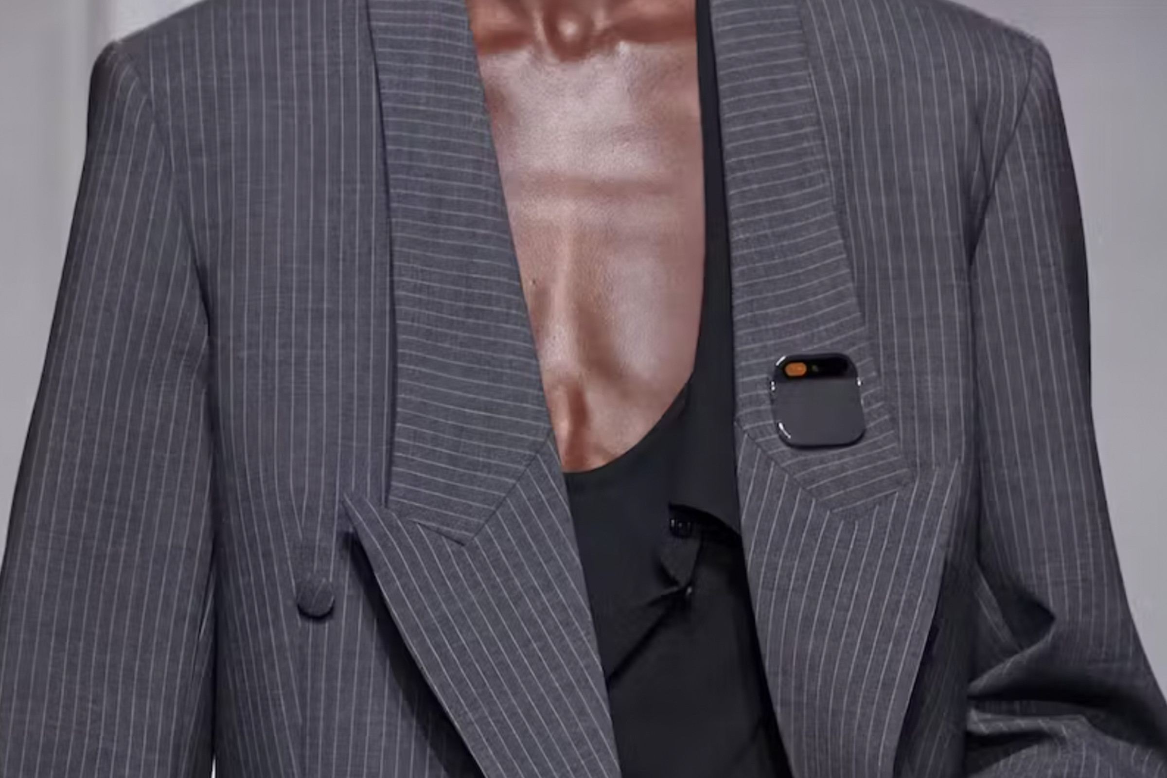 A photo showing Humane’s AI pin attached to a model’s suit during a fashion show.