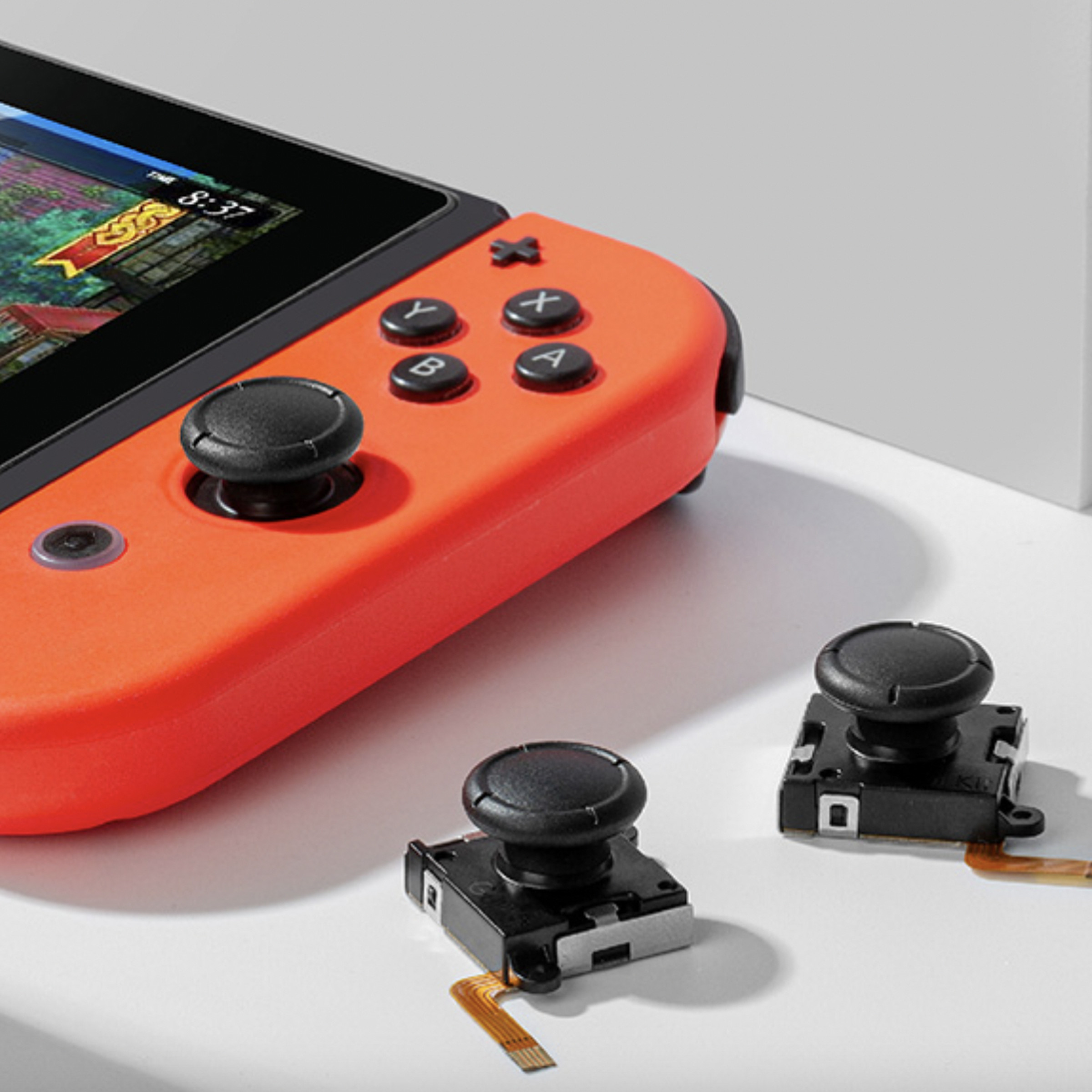 An image showing Gulikit’s joystick replacements next to a Nintendo Switch