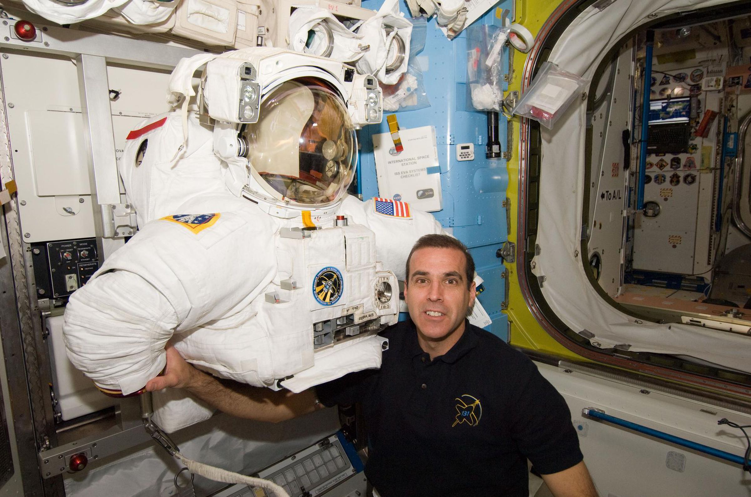 NASA astronaut Rick Mastracchio posing with a space suit torso.