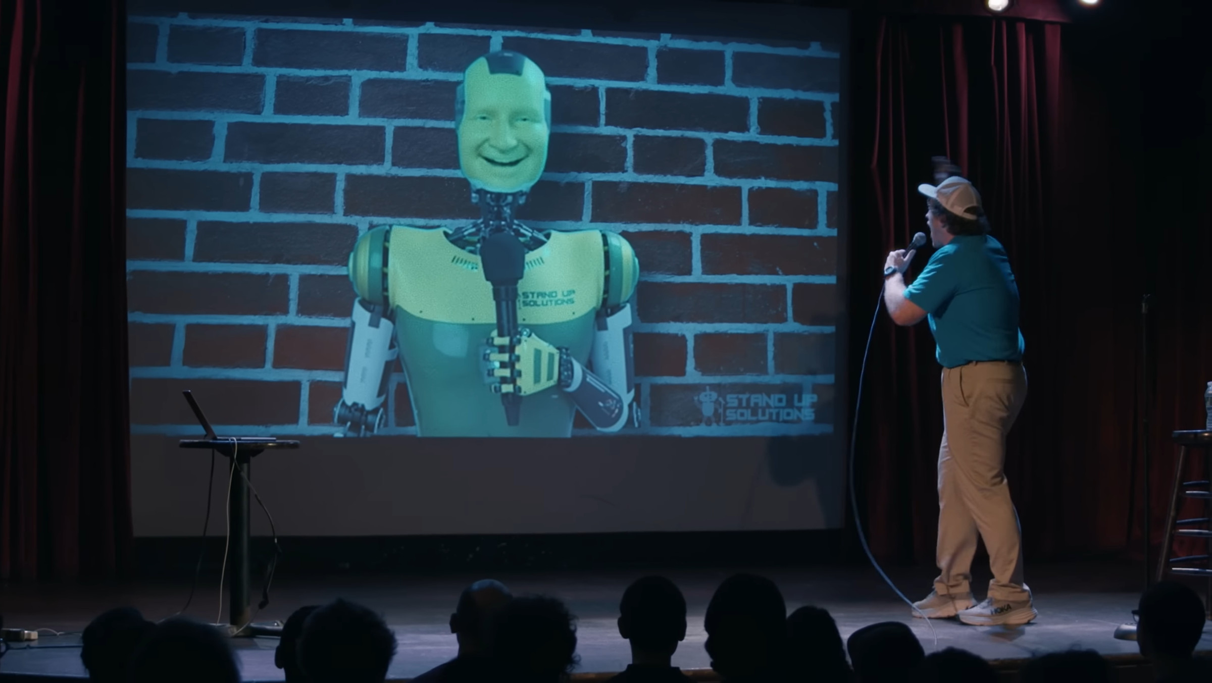 Comedian Conner O’Malley yelling at this AI standup robot on a screen