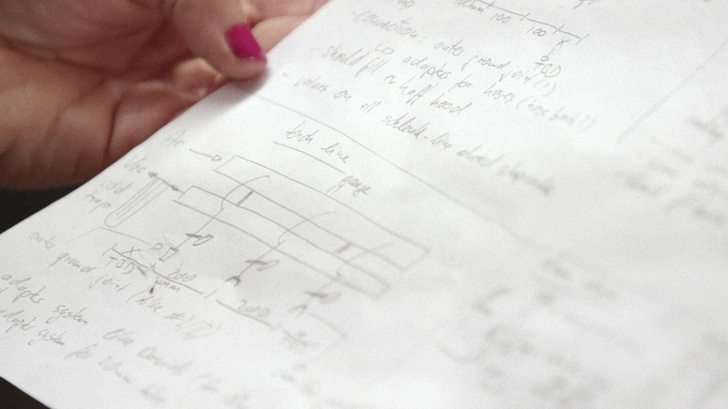 Roeger looks over a hand-drawn plan for a scientific instrument.