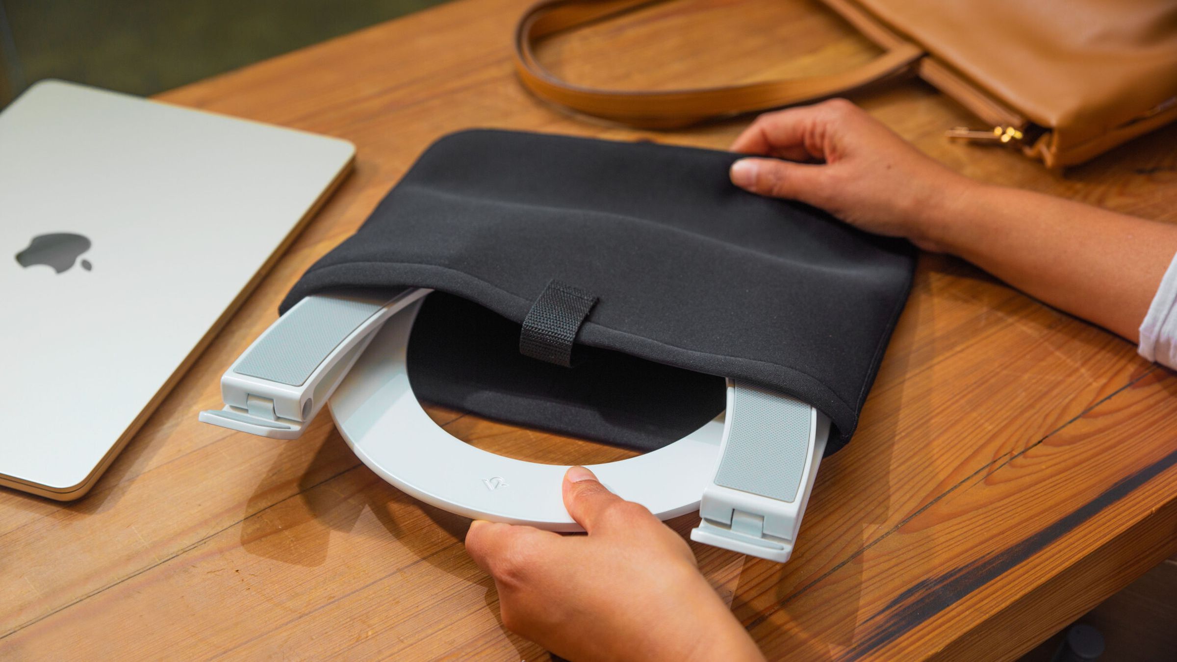 The Twelve South Curve Flex laptop stand being placed into its protective sleeve.