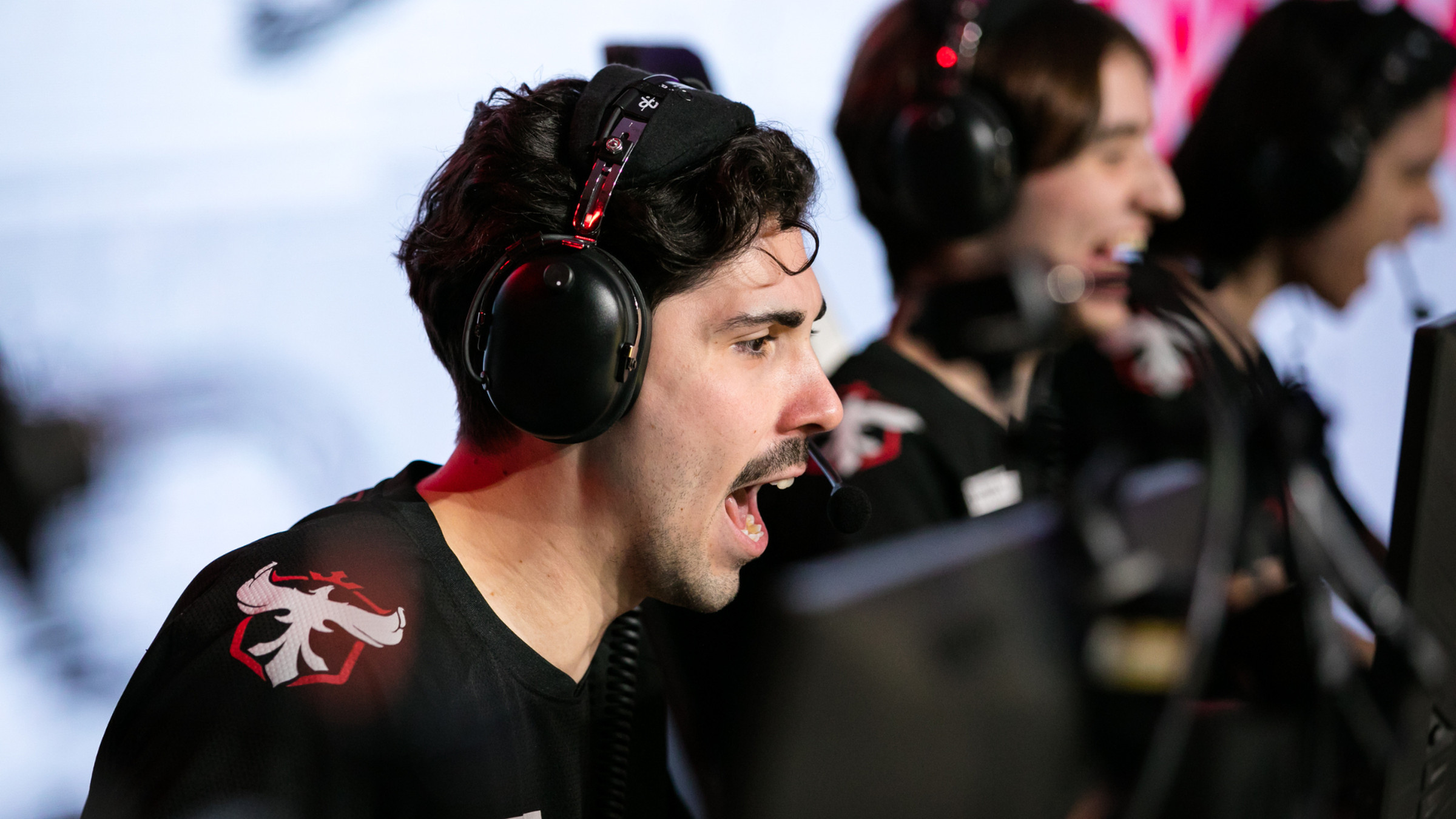 Photo from the Overwatch League 2022 playoffs featuring Atlanta Reign player Blake “Gator” Scott wearing heavy black headphones yelling at a computer screen while playing Overwatch 2