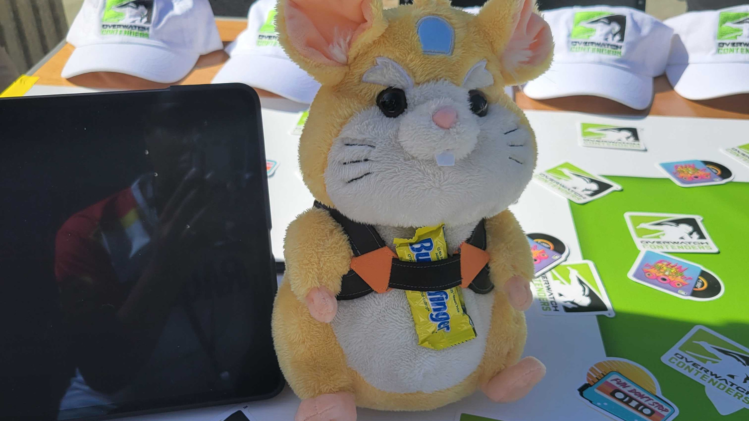 Photo of a stuffed hamster toy representing the Overwatch character Wrecking Ball with a fun-sized Butterfinger strapped to it.