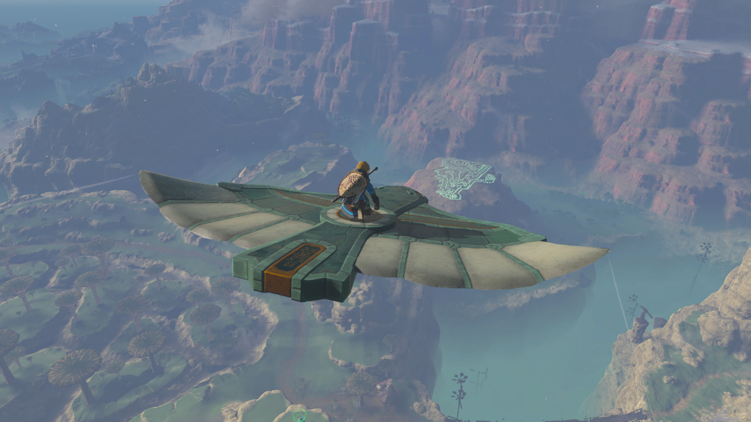 Screenshot from Tears of the Kingdom featuring Link flying on a glider overlooking Hyrule