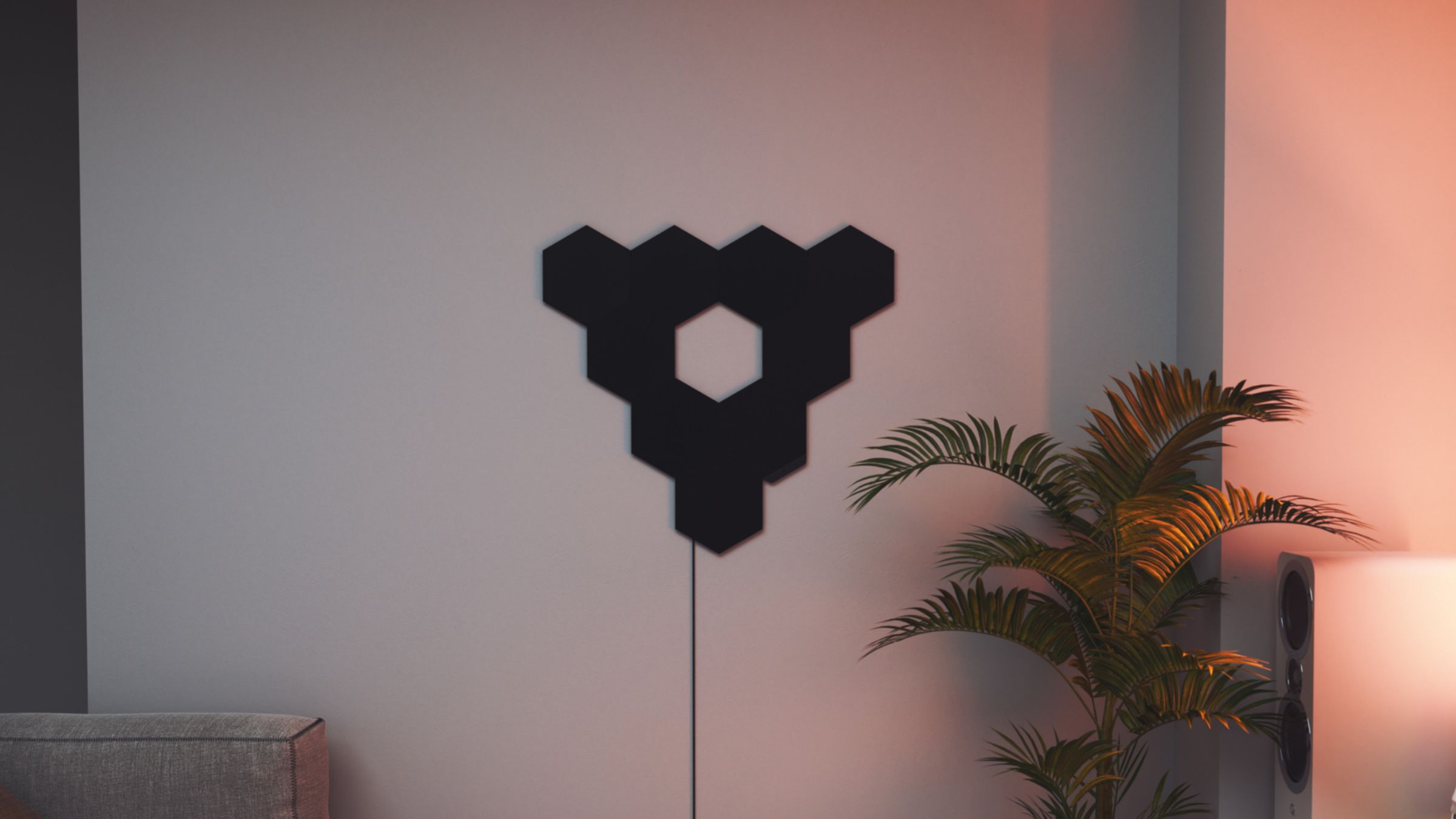 The Nanoleaf Shapes Ultra Black Hexagon lighting panels against a white wall.