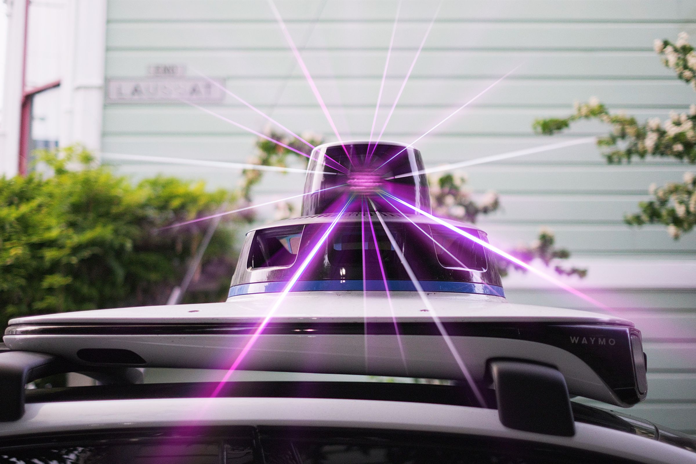 Close up of Lidar system on top of an autonomous vehicle with purple laser emitting from it.