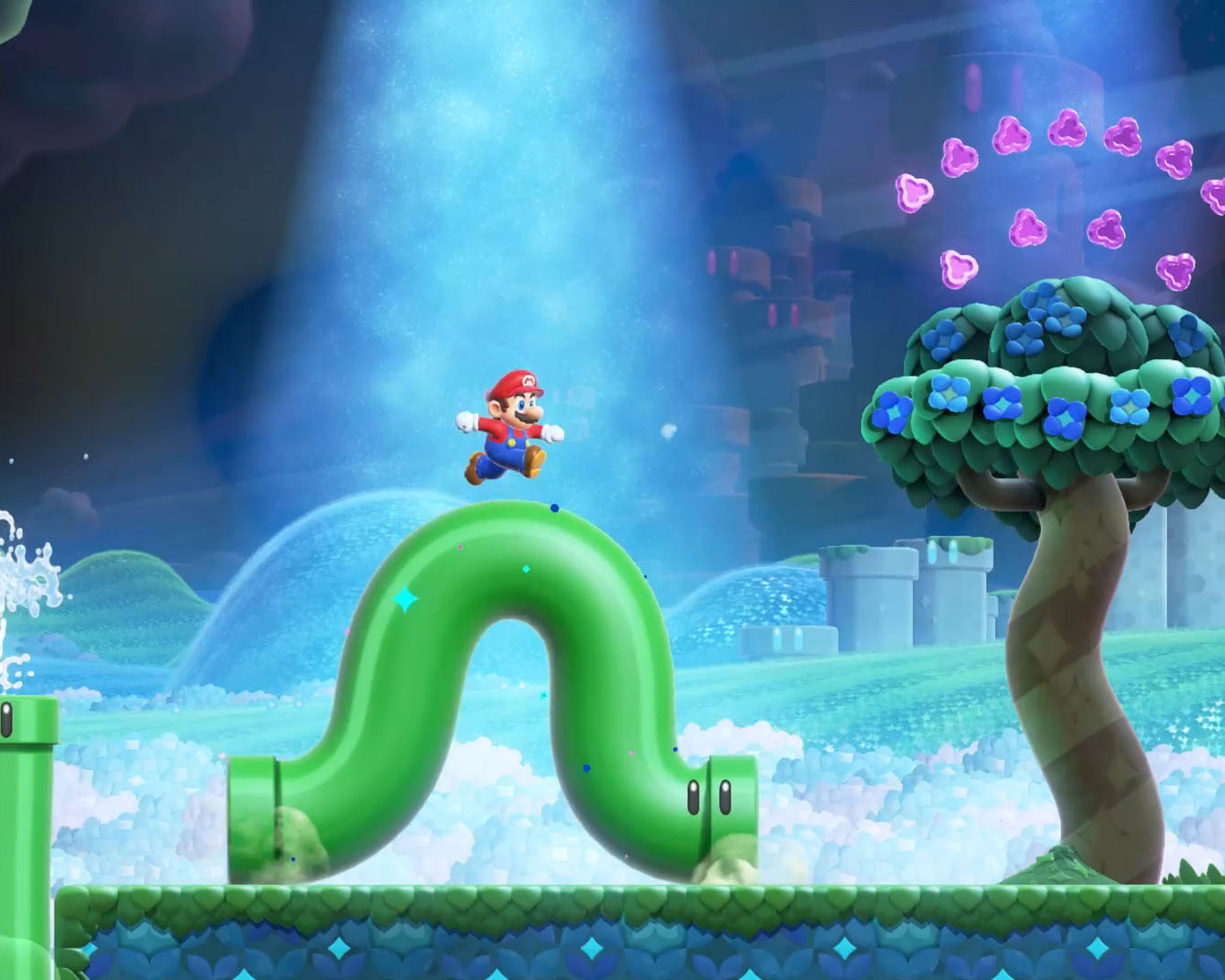 A screenshot from the video game Super Mario Bros. Wonder in which Mario stands on a wiggling green pipe in a surreal fantasy world.