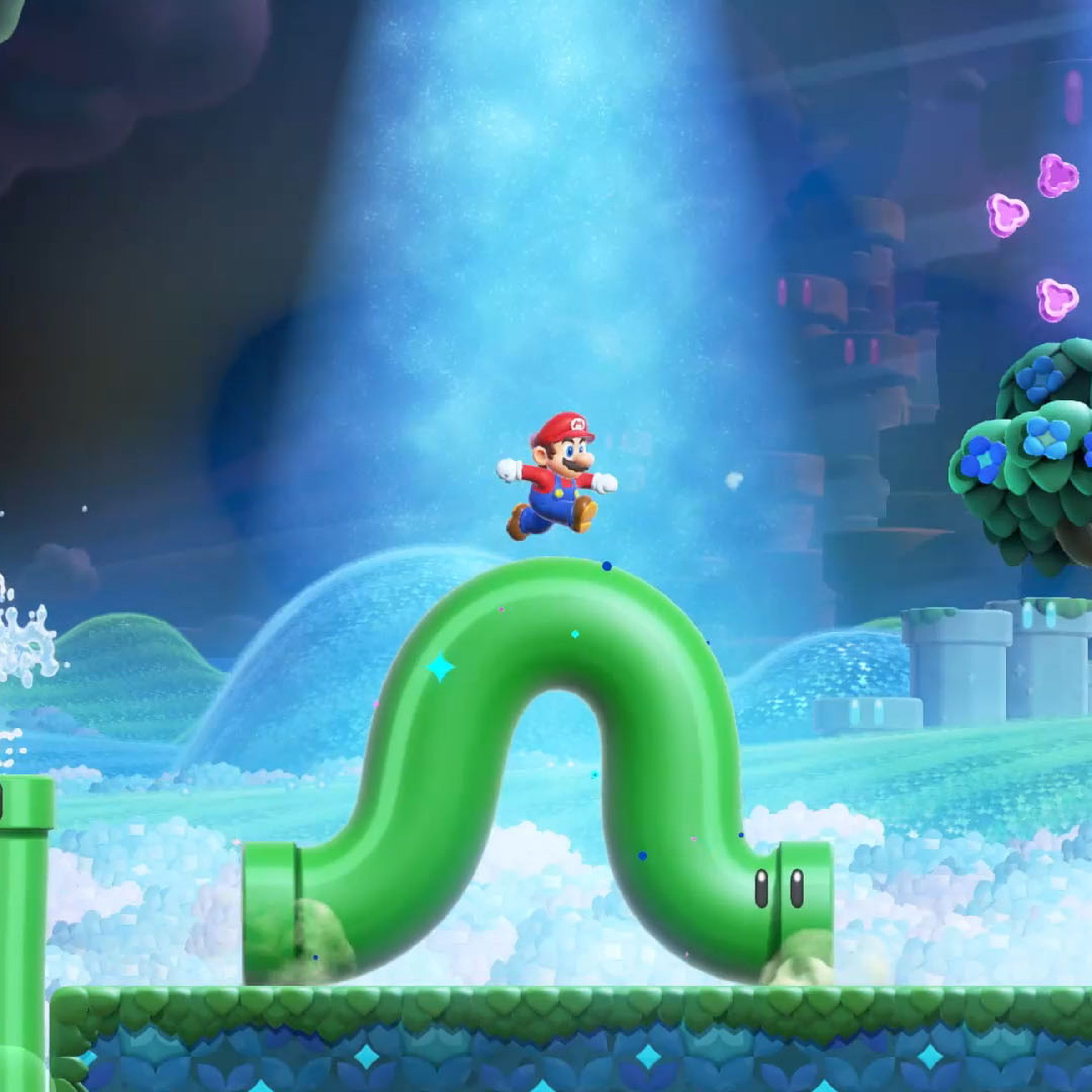 A screenshot from the video game Super Mario Bros. Wonder in which Mario stands on a wiggling green pipe in a surreal fantasy world.
