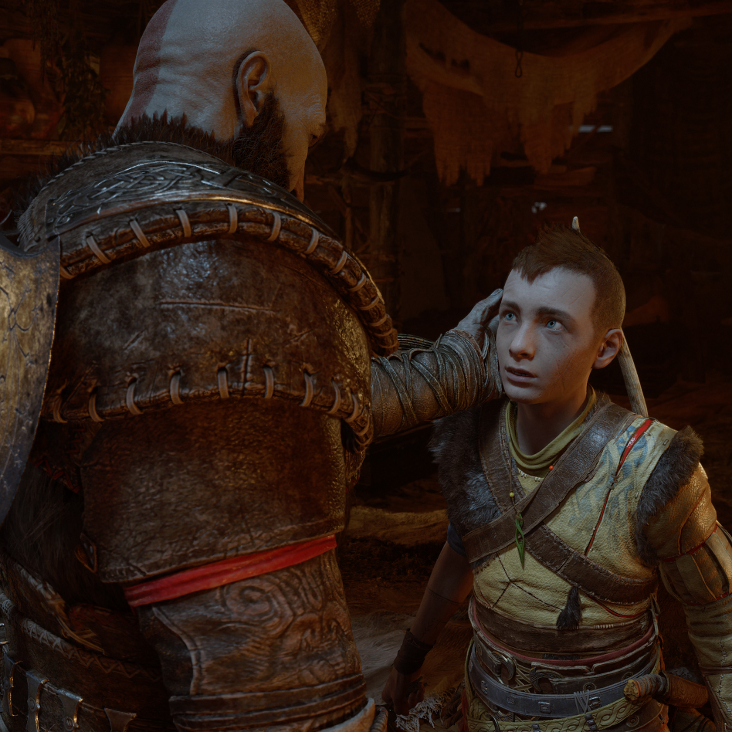 Screenshot from God of War Ragnarök featuring Kratos gently touching the face of his teenage son, Atreus