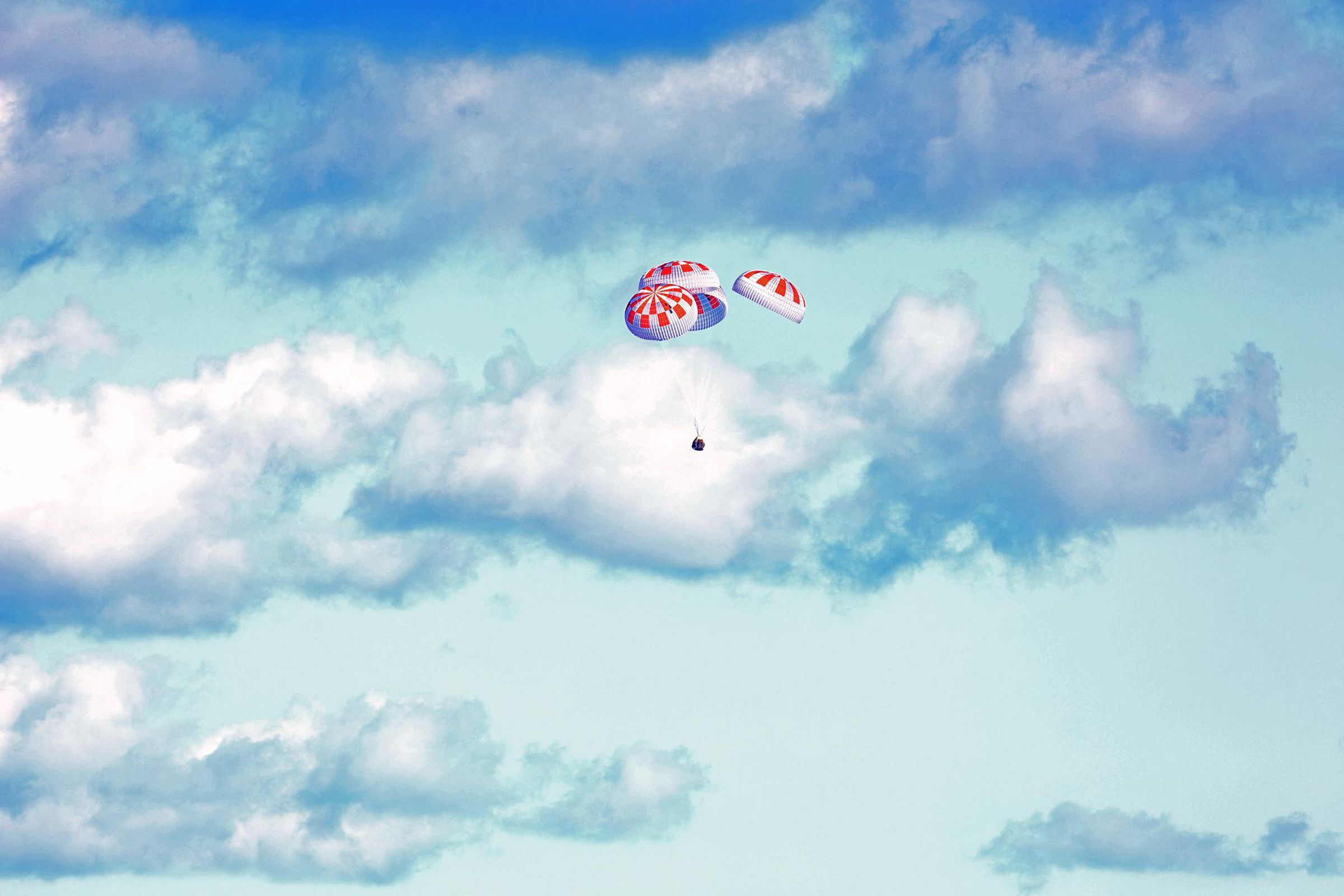 SpaceX’s Crew Dragon, with its parachutes deployed, as it splashed down on its first uncrewed flight test.