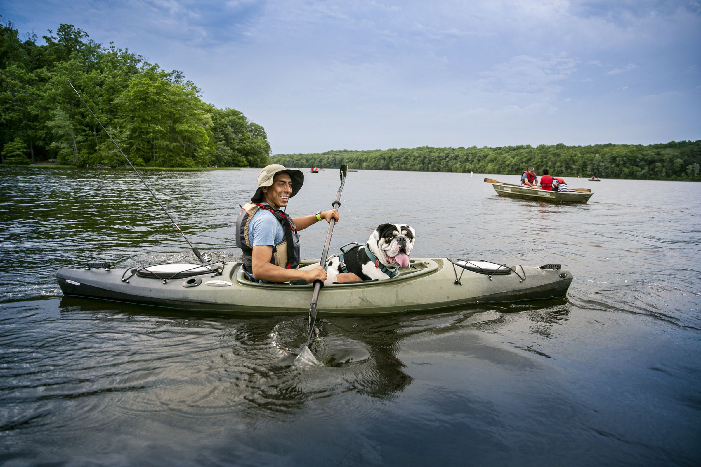 Man and dog smiling on a canoe.