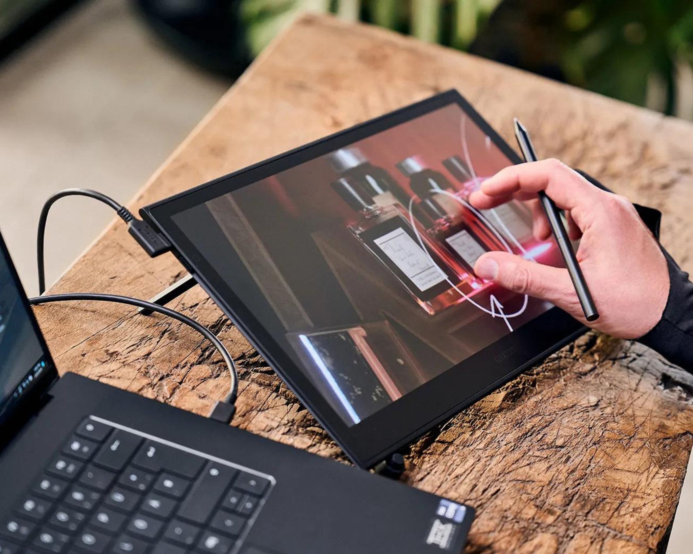 Someone using the Wacom Movink 13 display drawing tablet with a connected laptop.