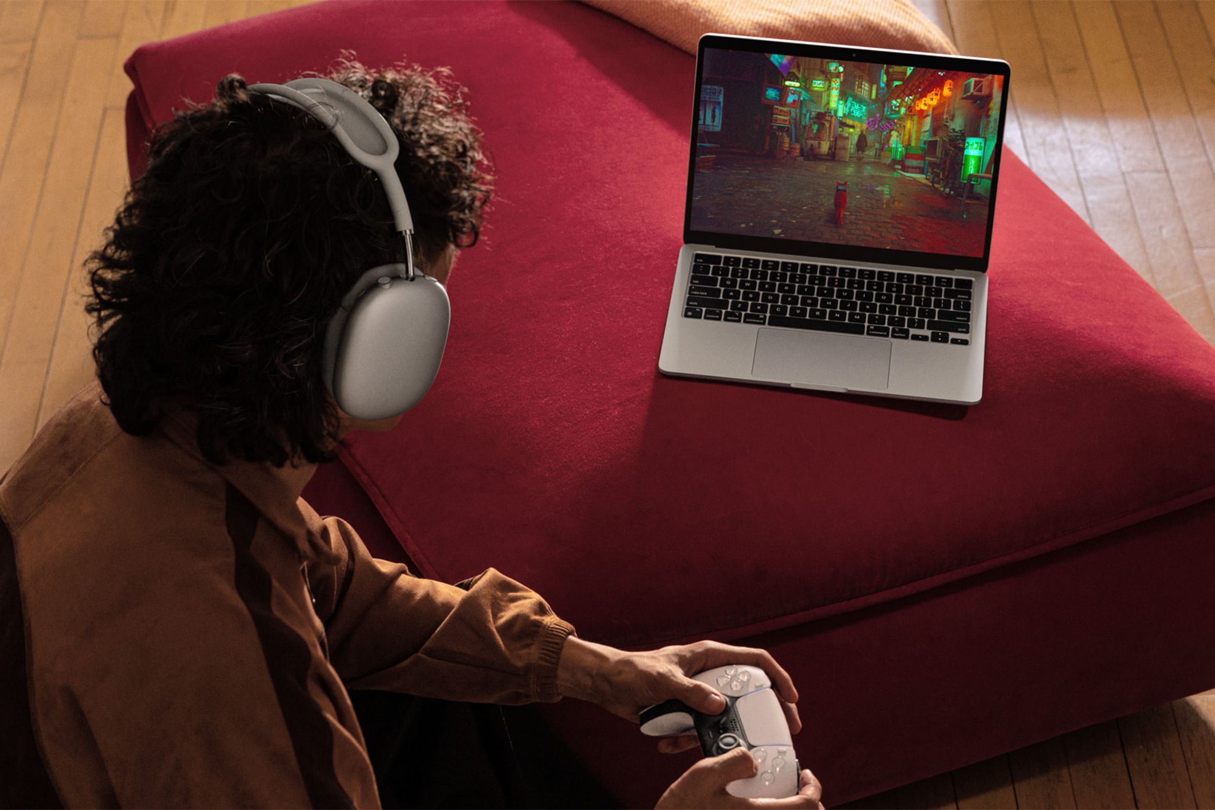 A person gaming on the new MacBook with headphones on.
