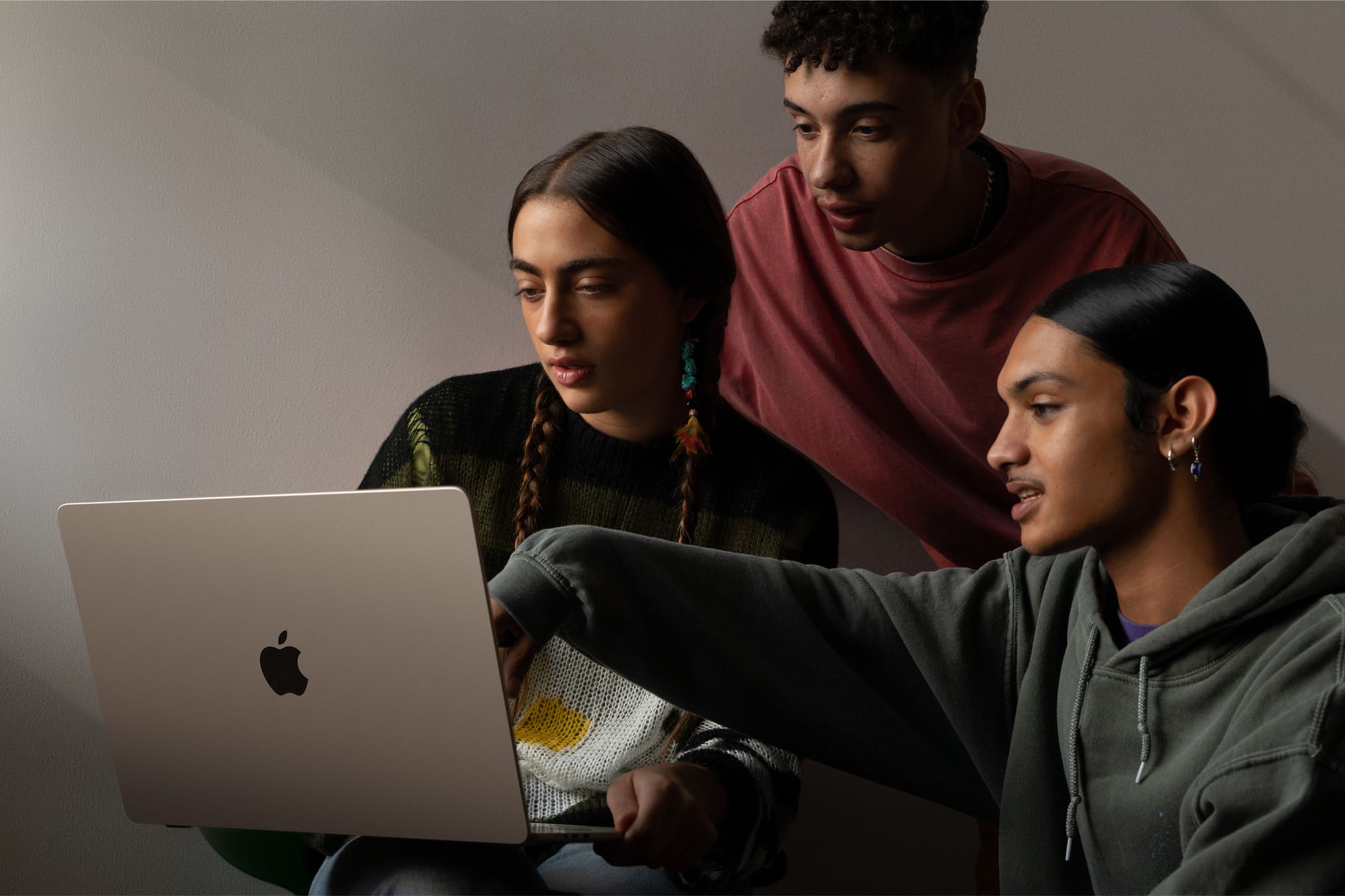 Three people using and looking at the bigger 15-inch MacBook Air.