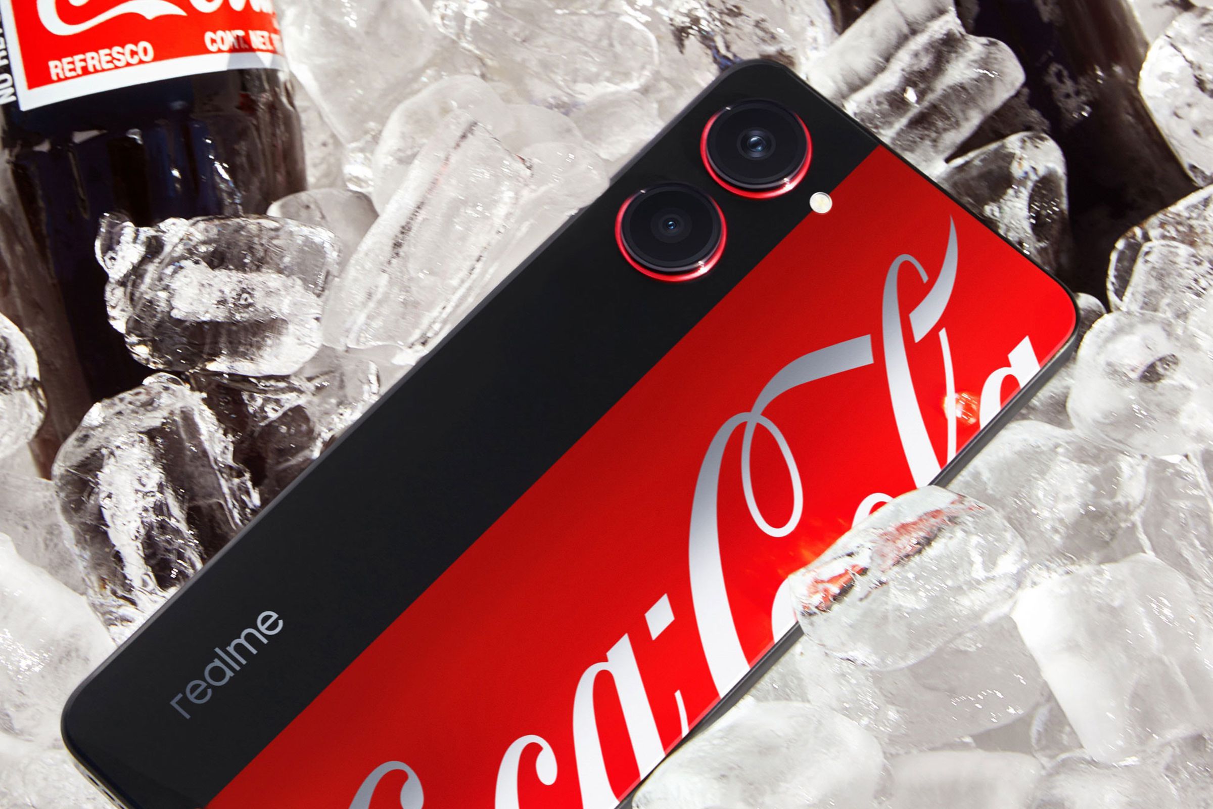 Realme Coca-Cola phone on a bed of ice next to a bottle of Coca-Cola.