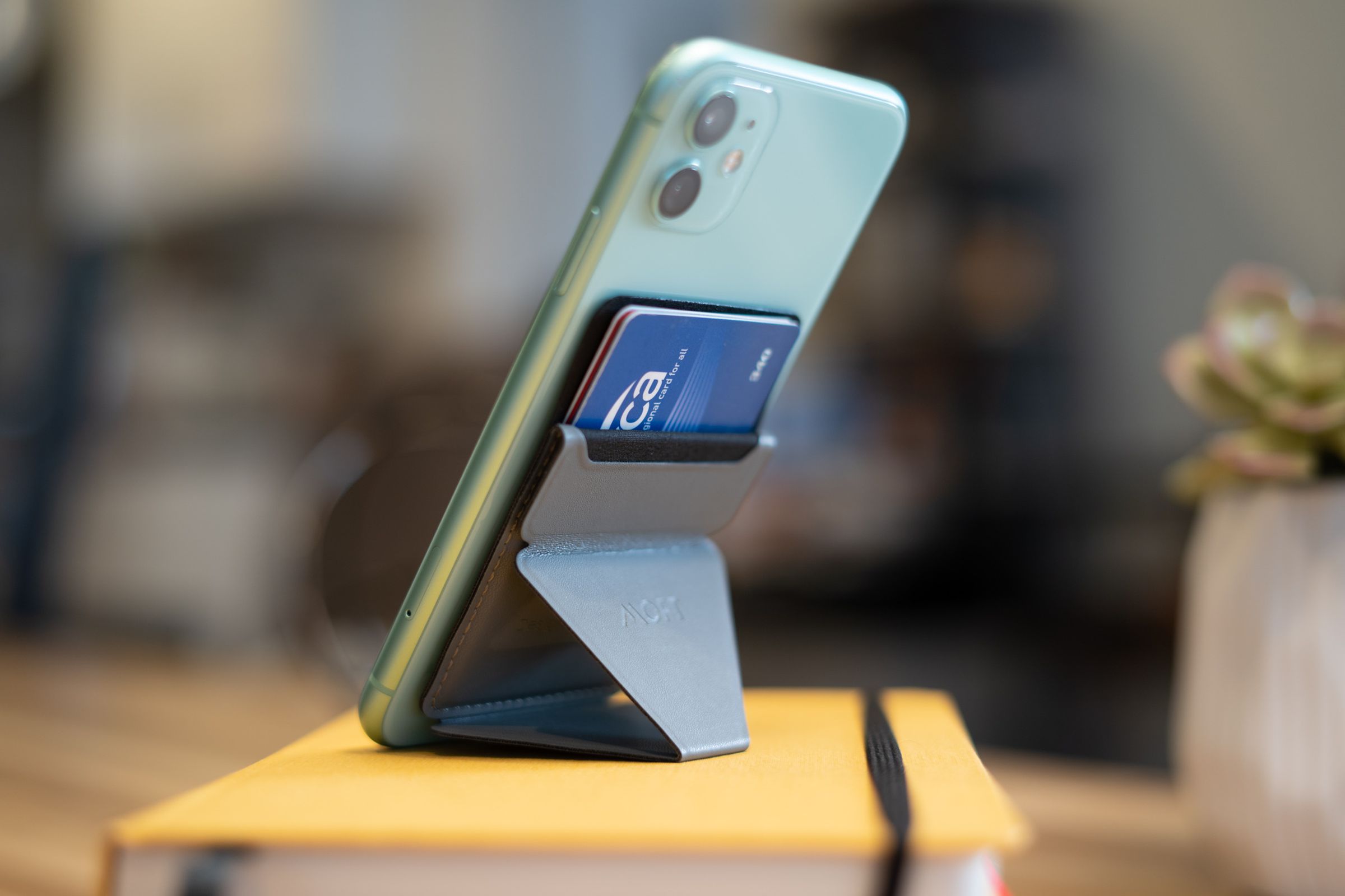 Photo of Moft stand propped in portrait orientation with cards in the wallet pocket.
