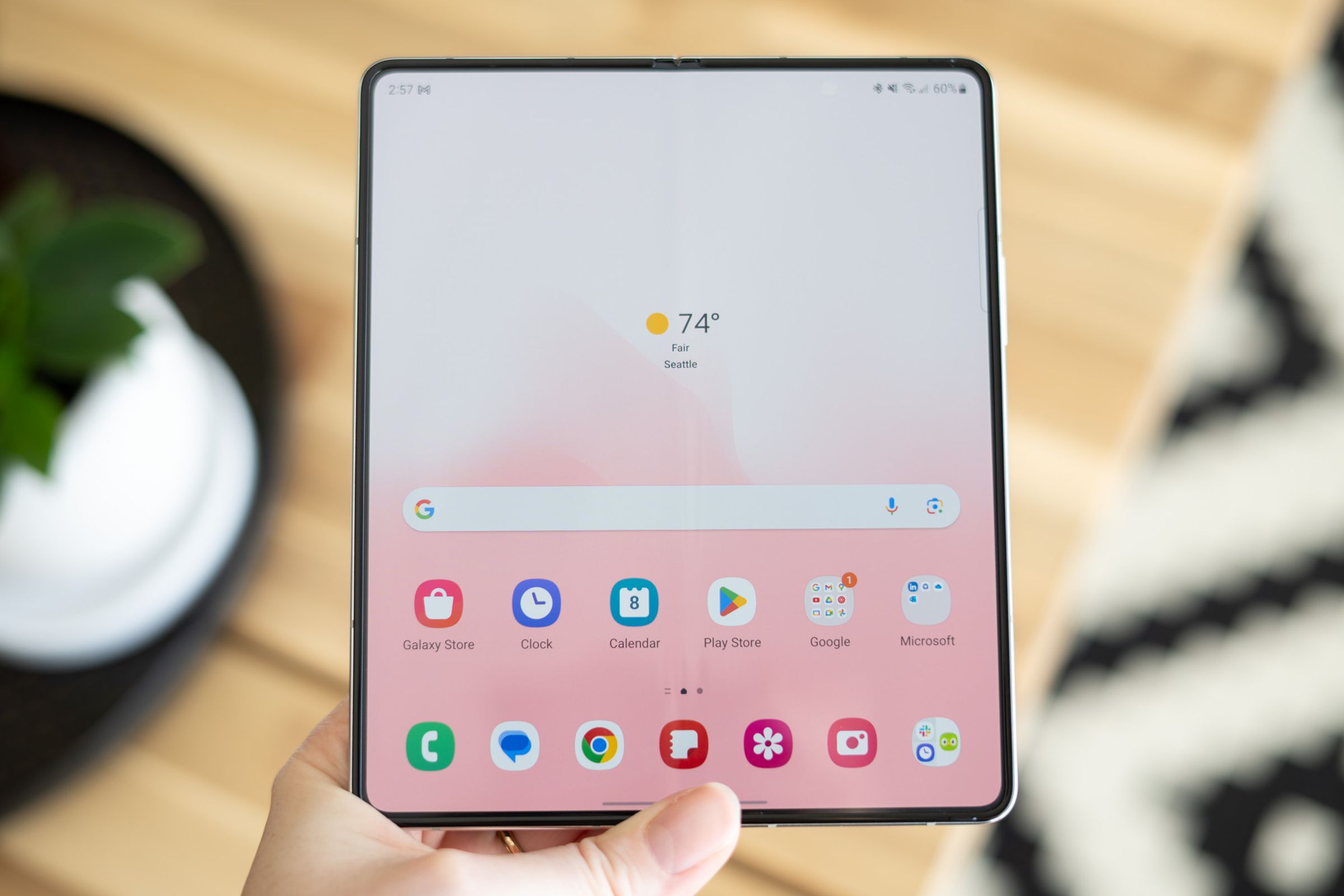 Samsung Galaxy Z Fold 5 unfolded in-hand showing home screen.