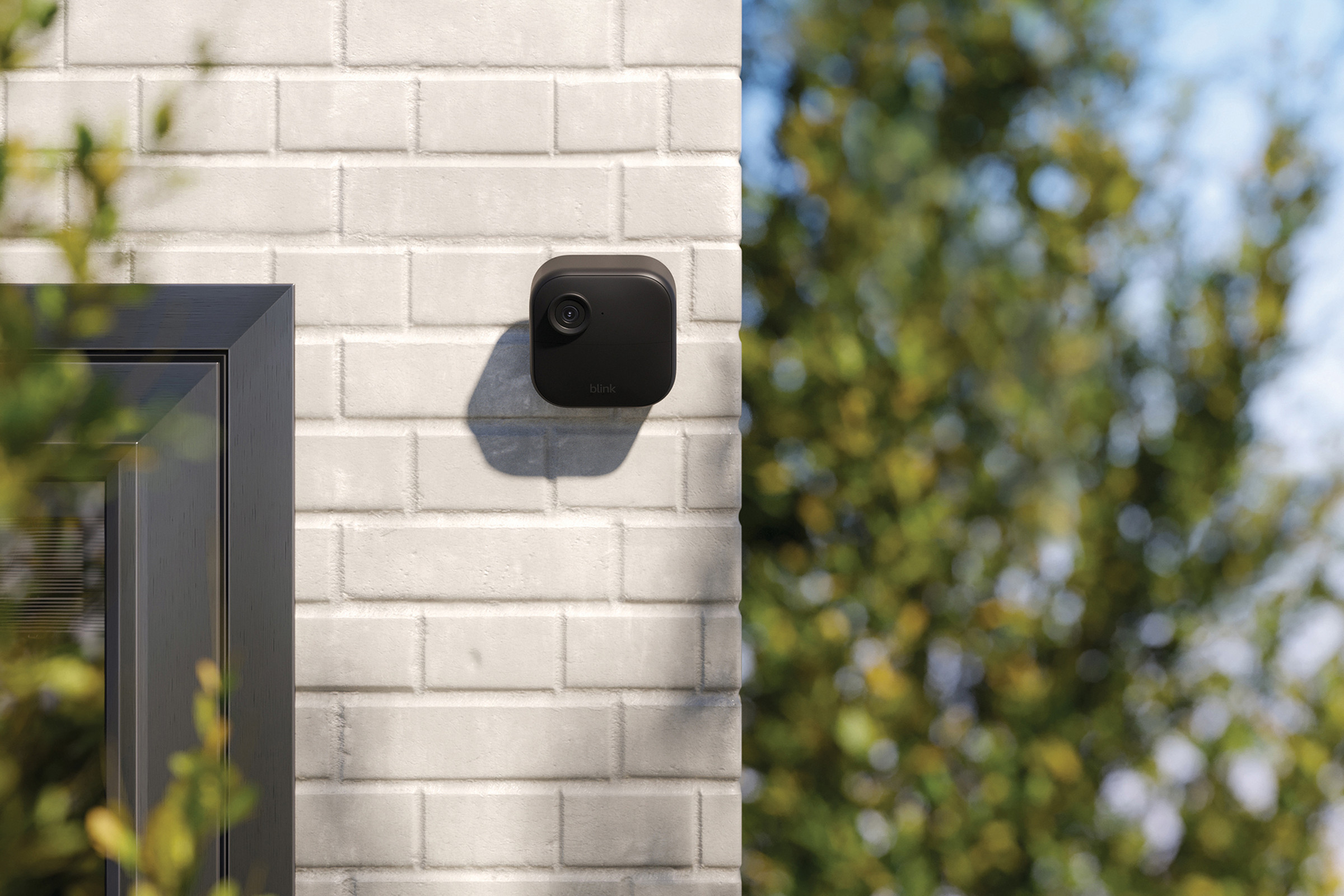 A black wireless camera mounted on a wall.