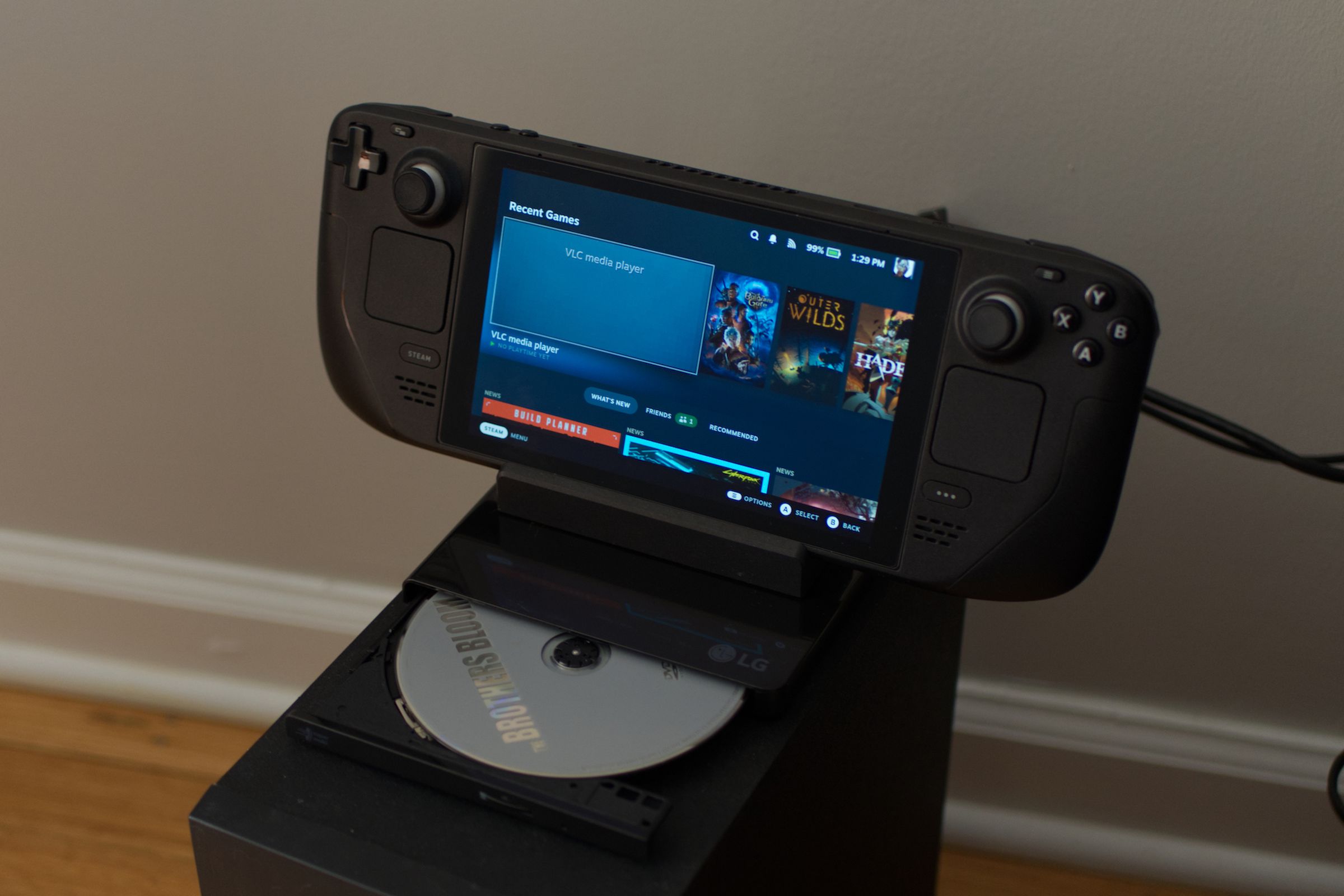 A photo of a Steam Deck with a DVD player attached.