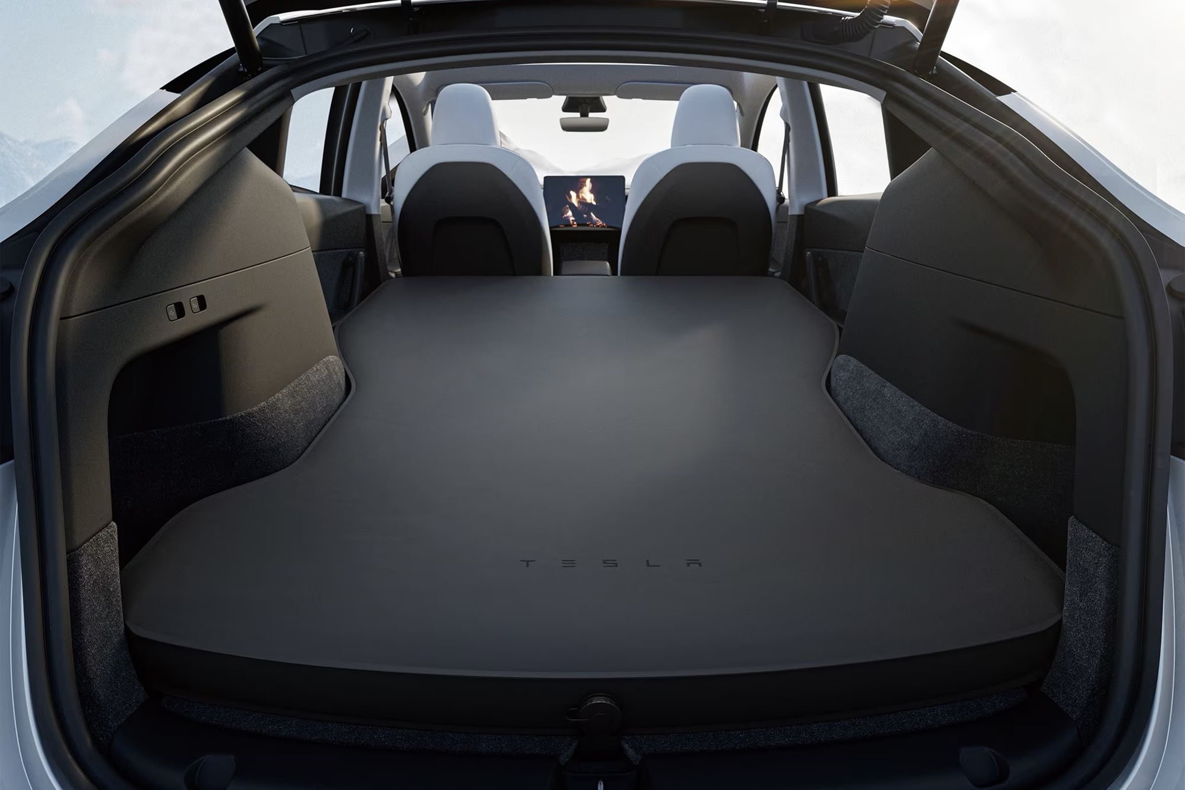 rear of model y hatch open with mattress pad laid out up to the front seats.