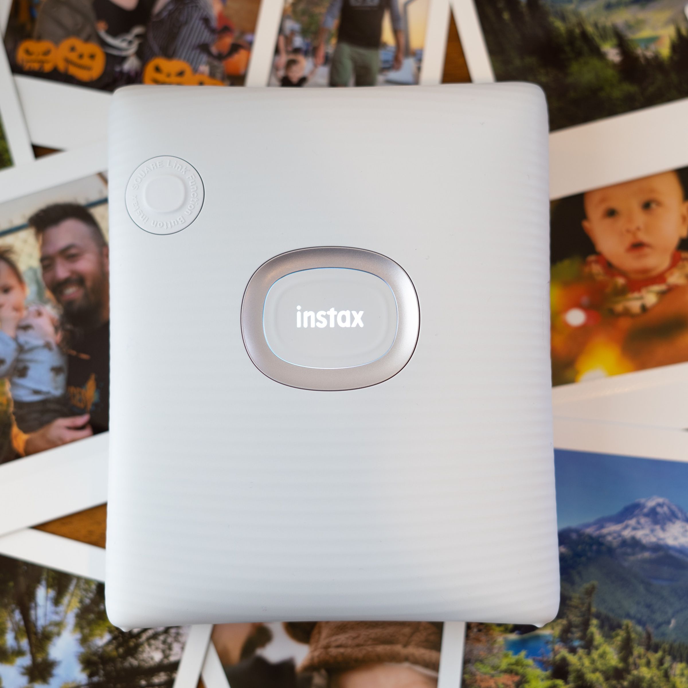 Instax Square printer with logo illuminated on a background of square prints.