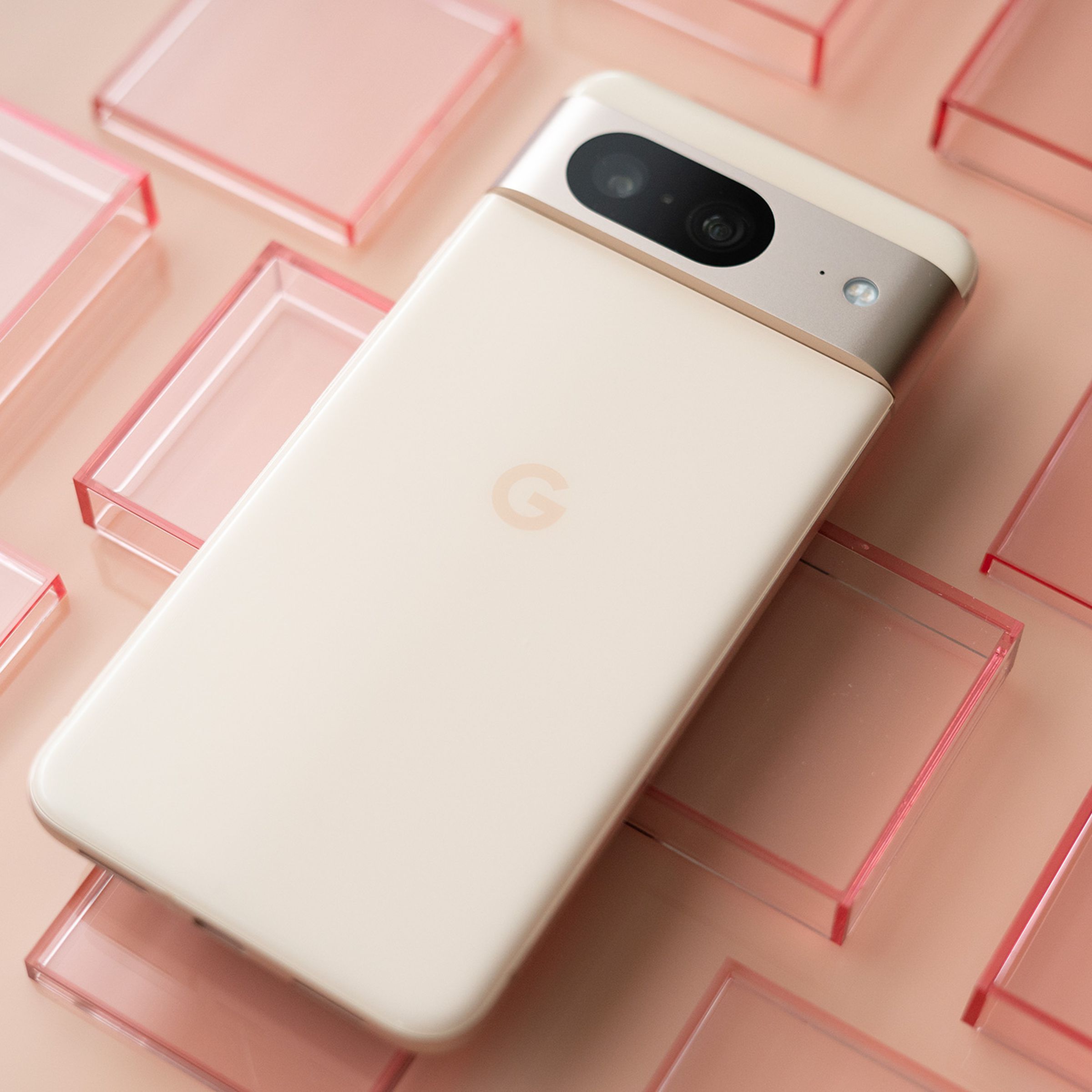 Google Pixel 8 in pink on a pink background with red transparent squares.