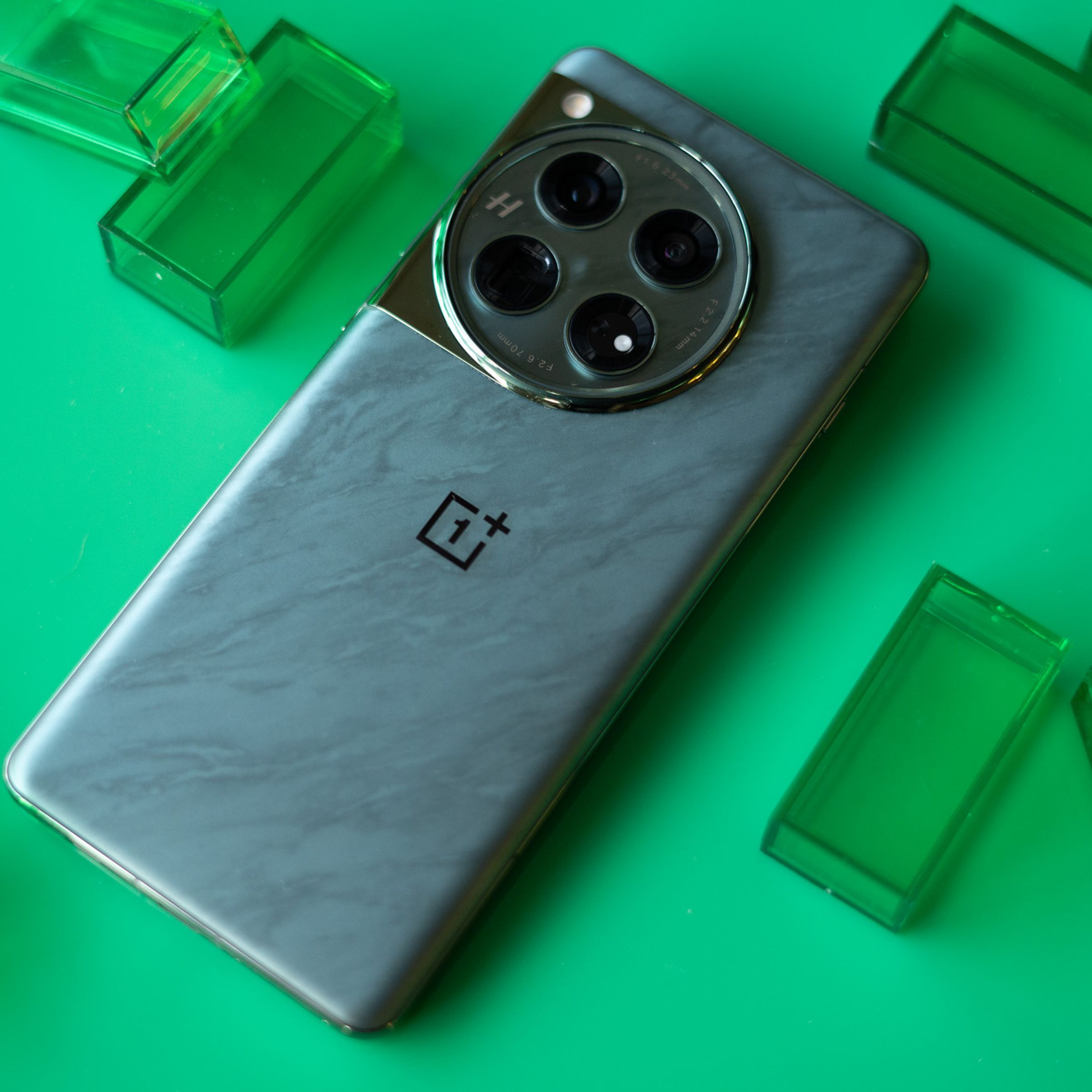 OnePlus 12 on a green background showing back panel of green color option.