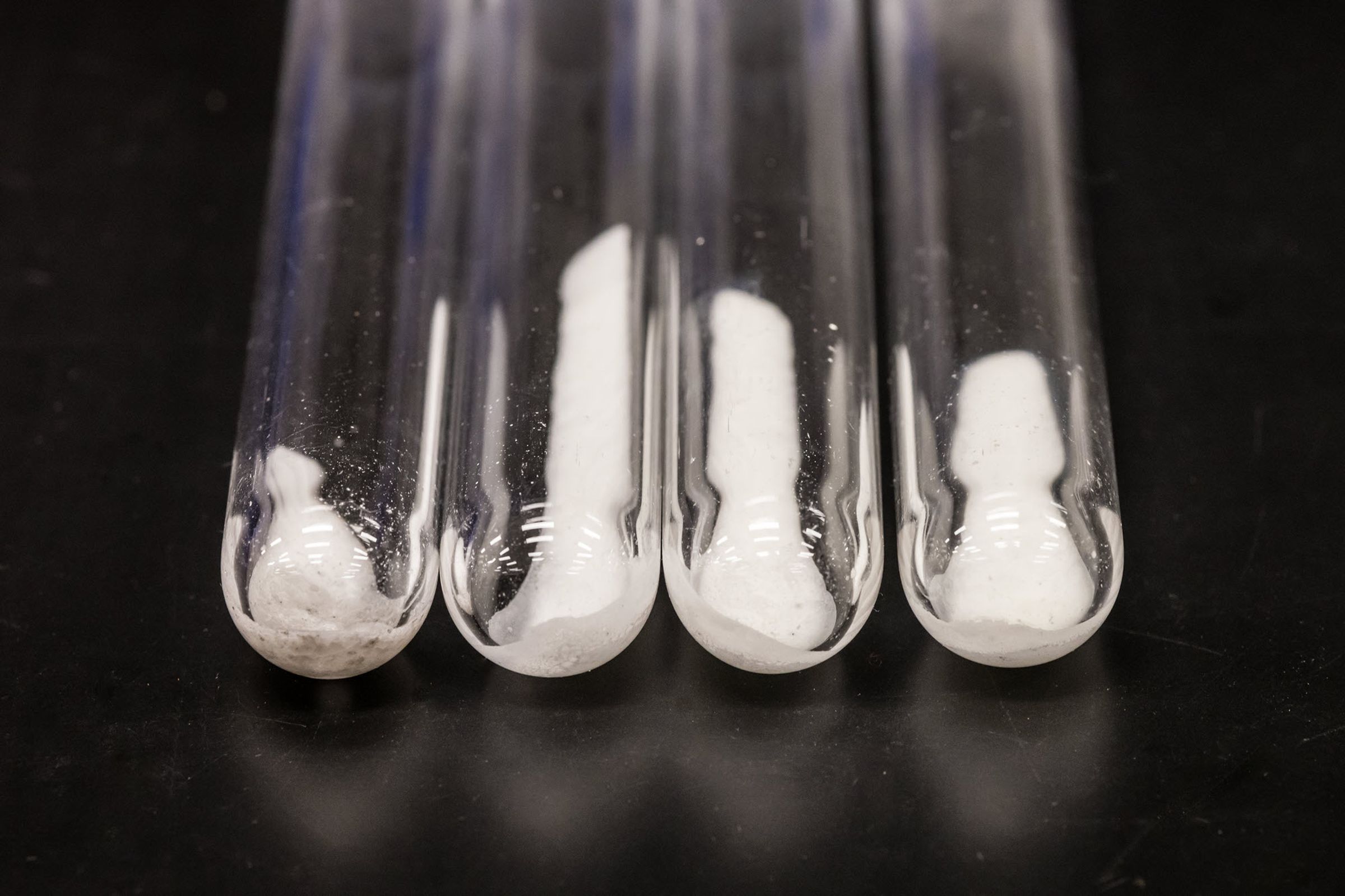 White powder inside four clear glass test tubes.