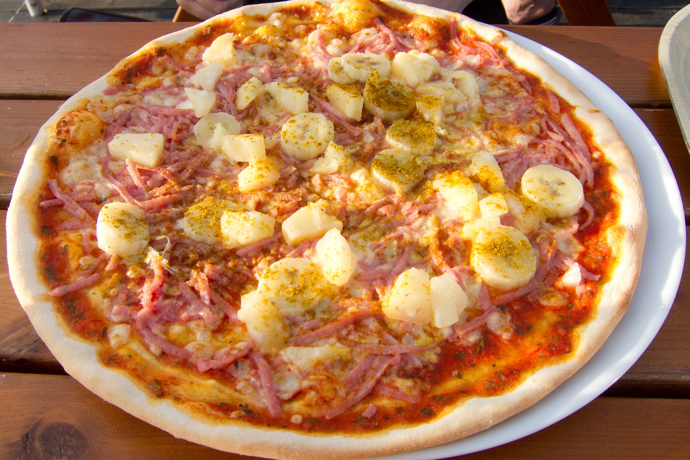 Bananas, pineapple, curry powder, and ham on a pizza 