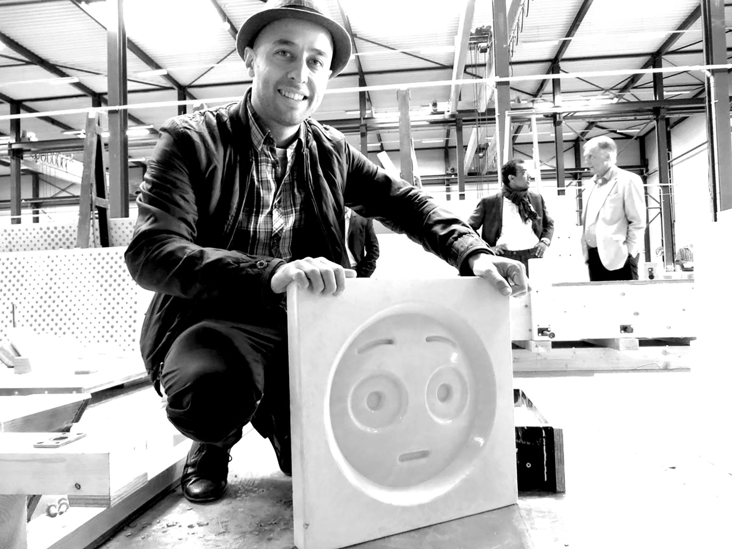 Architect Changiz Tehrani poses with one of the concrete emoji. 