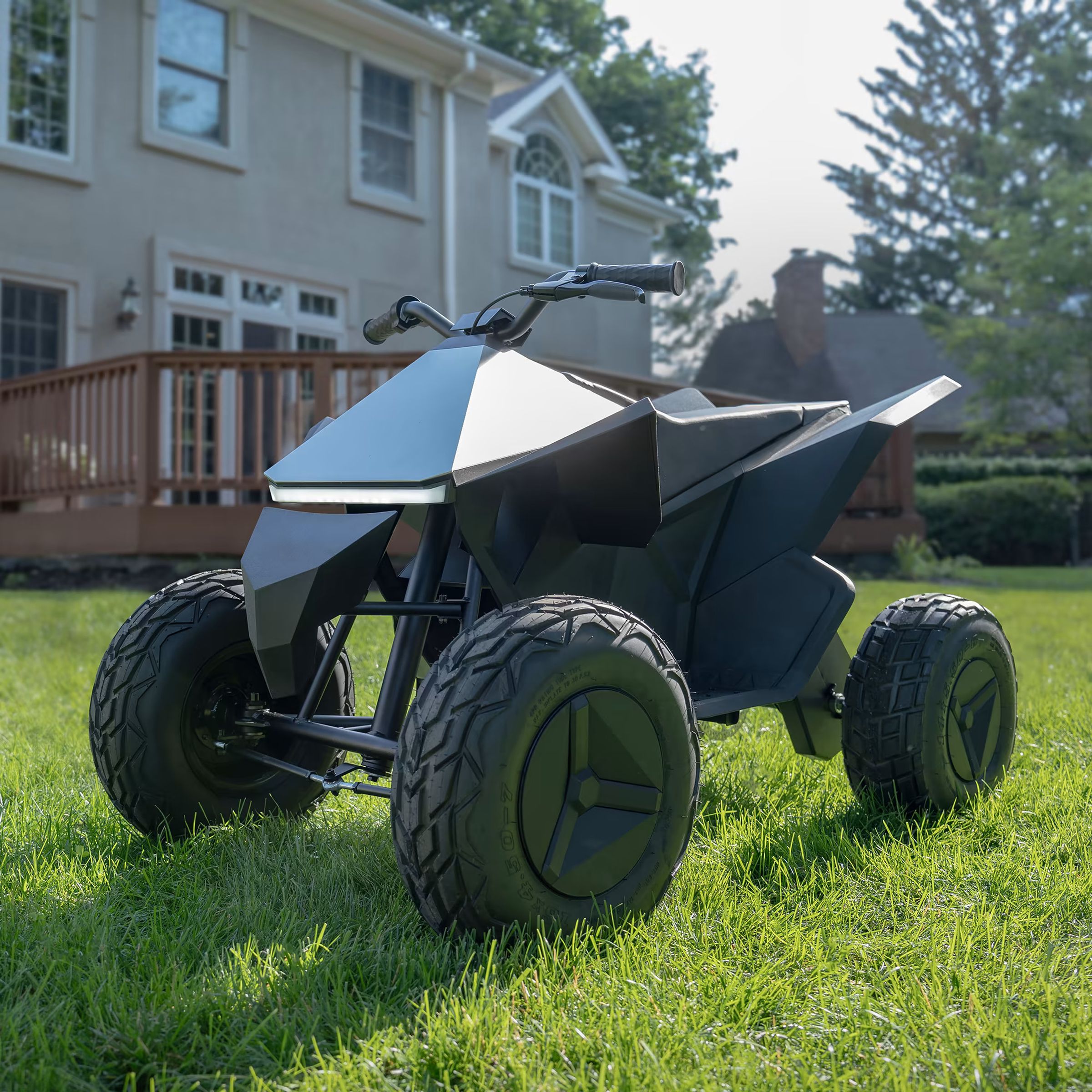 A Tesla Cyberquad for Kids parked on a grassy garden.