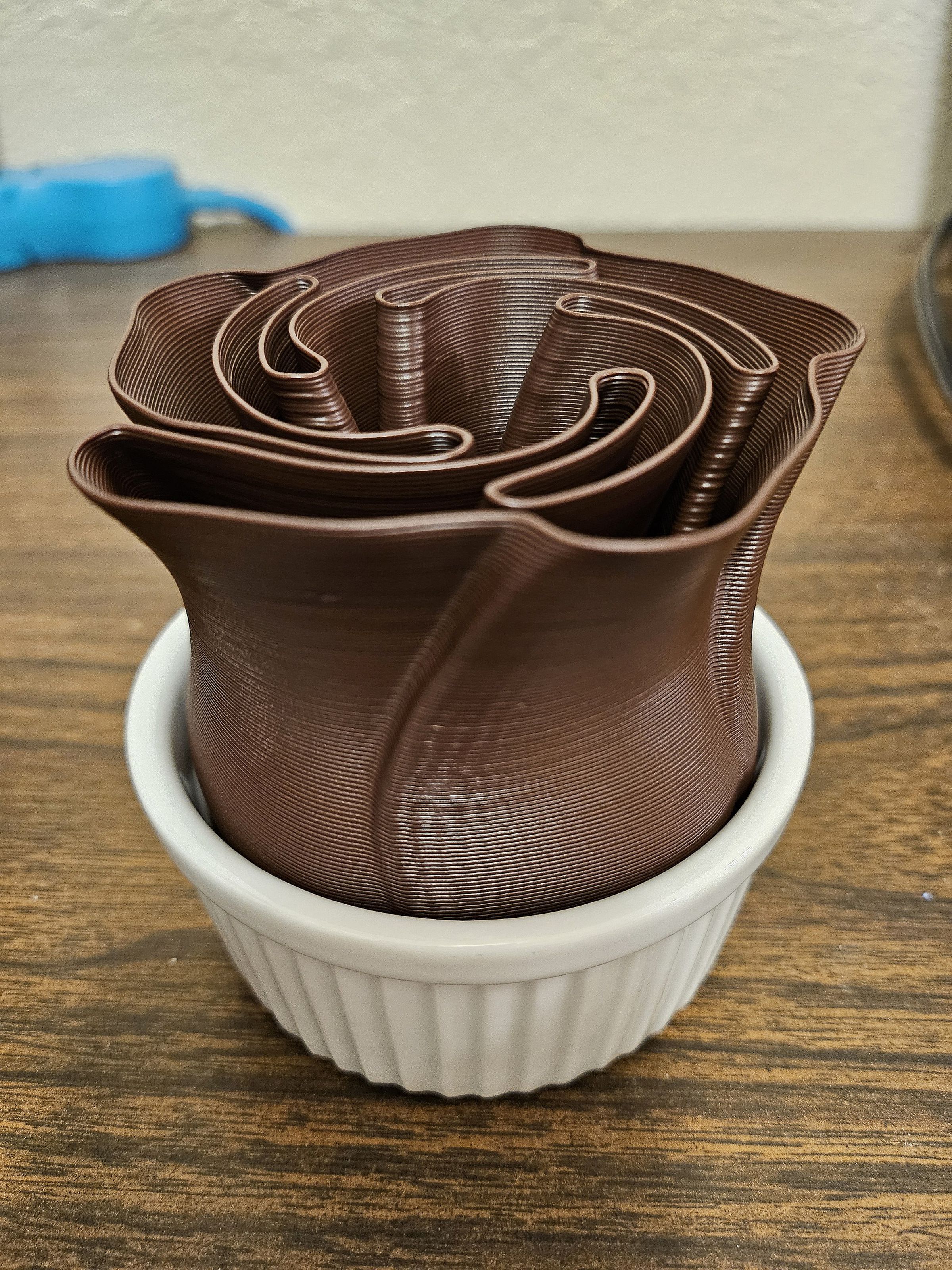 The chocolate rose sits in a porcelain ramekin.