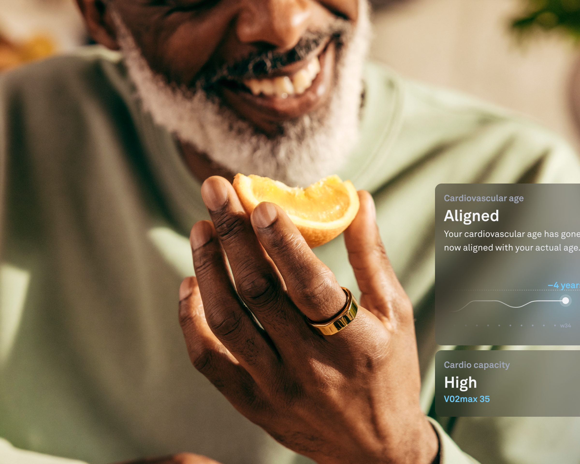 Man eating orange while wearing Oura Ring with a render of the new cardiovascular age feature.