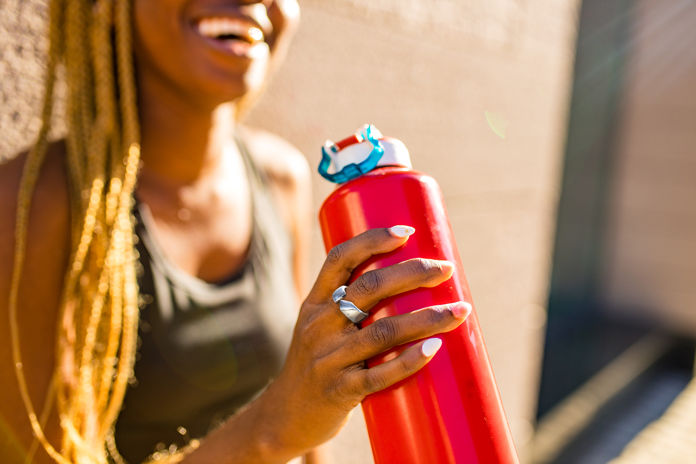 Woman wearing Movano’s Evie Ring while holding a water bottle.
