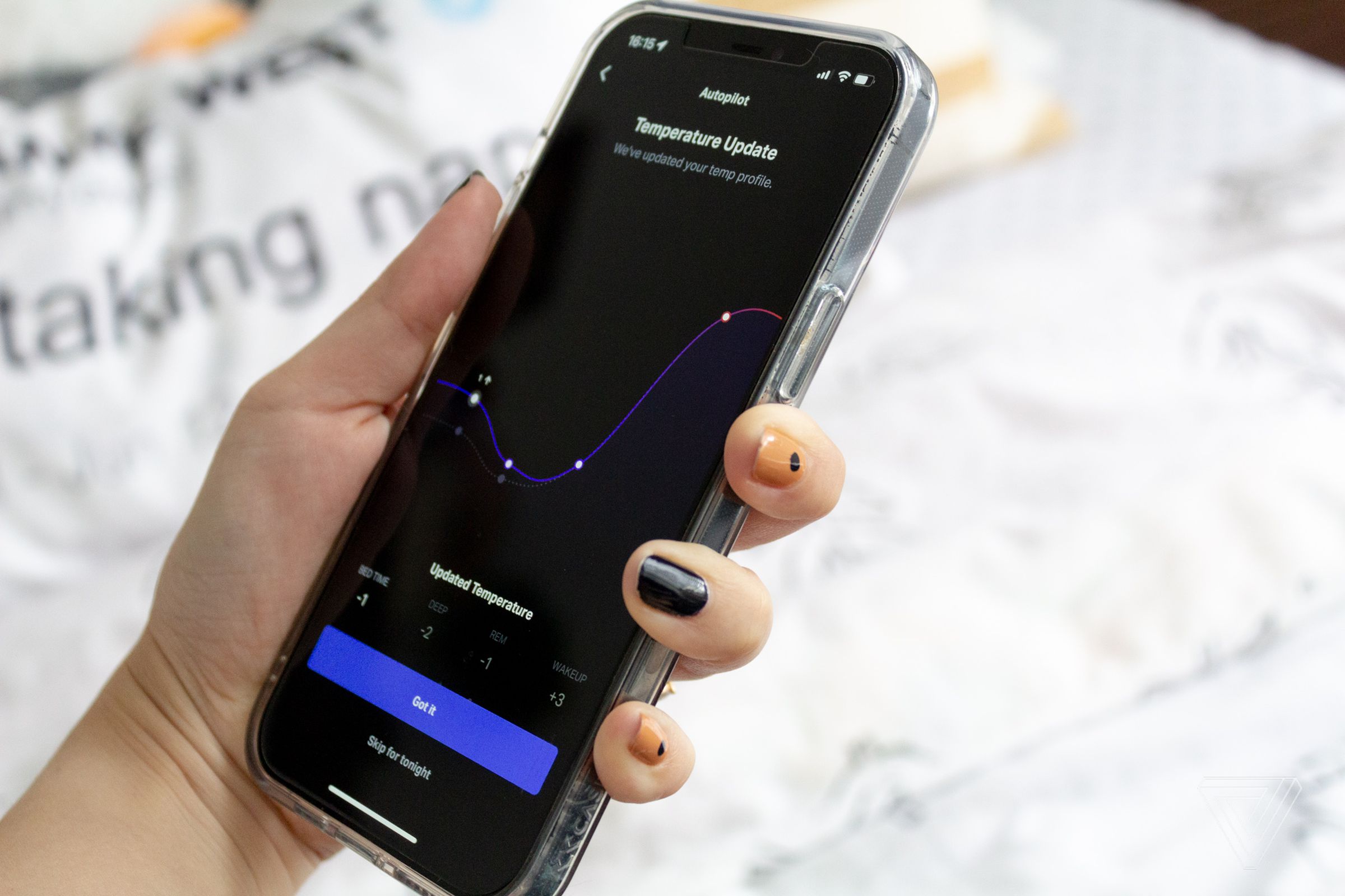 A hand holding the a phone displaying the Temperature settings on the Eight Sleep app