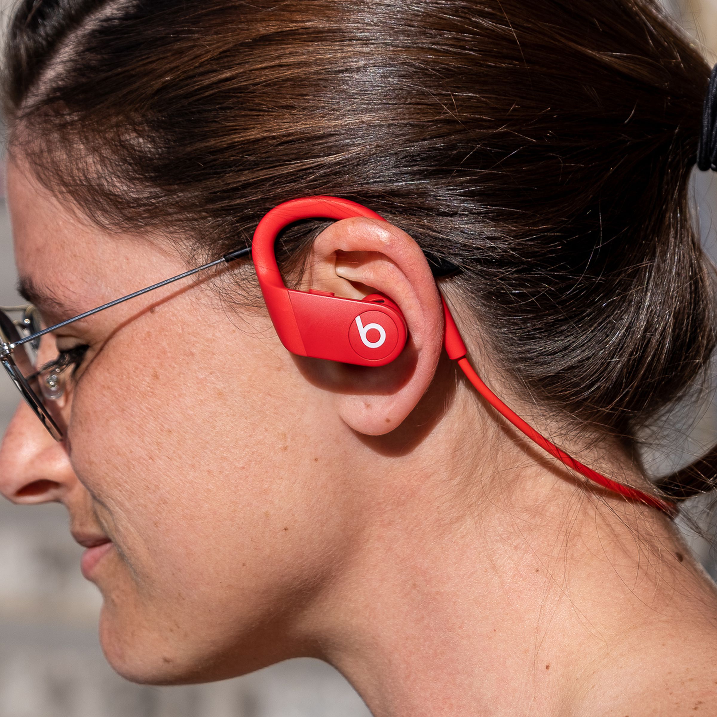 Powerbeats 4 earbuds seen from a side profile view.