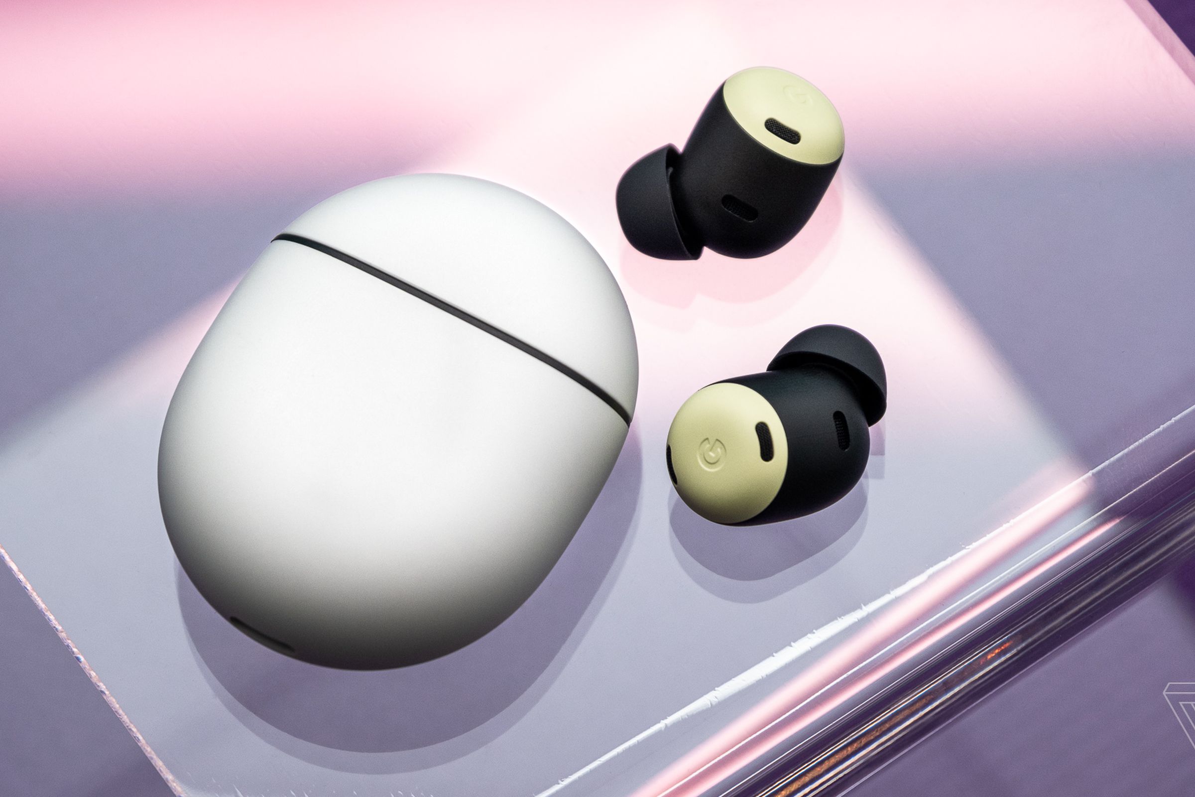 Obraz słuchawek Google Pixel Buds Pro na przezroczystym stojaku z fioletowym tłem.