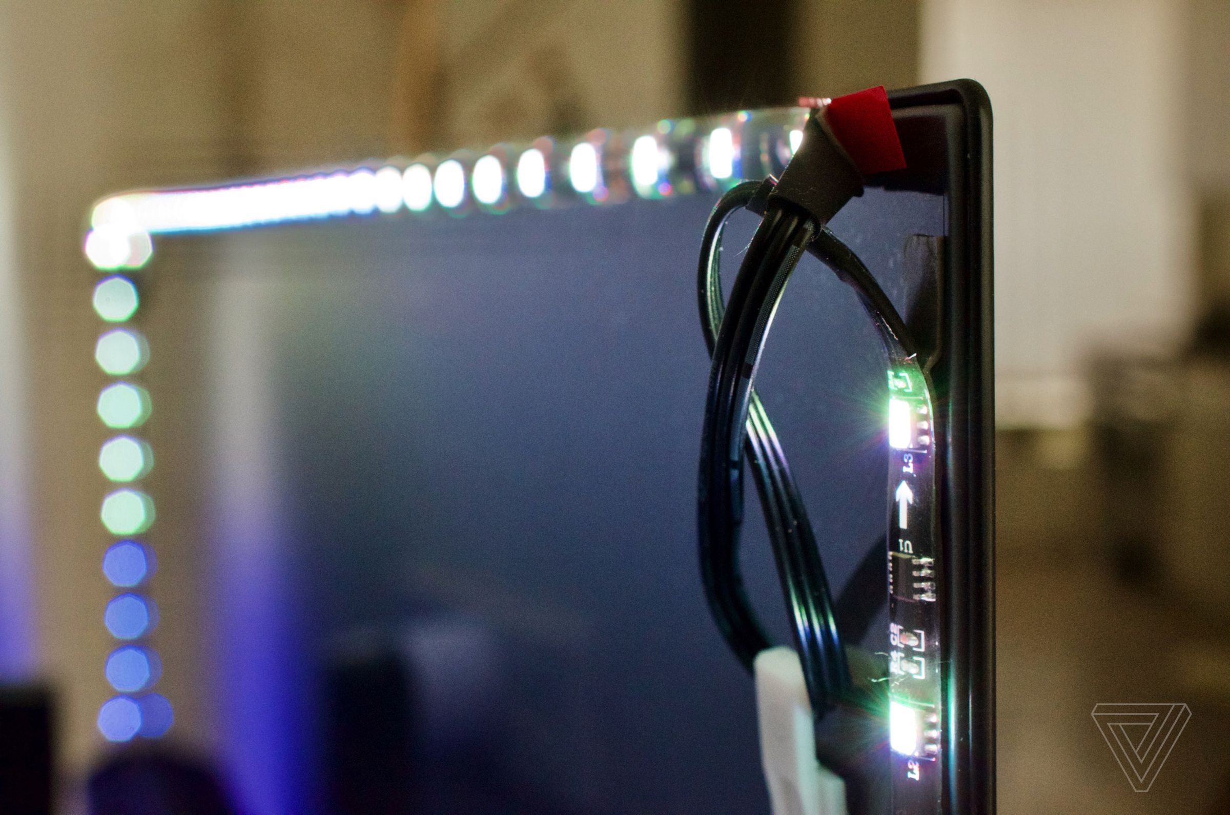 <em>LED strips have to be looped at the corners on a 55-inch TV. Slack can be held down by included adhesive clamps.</em>