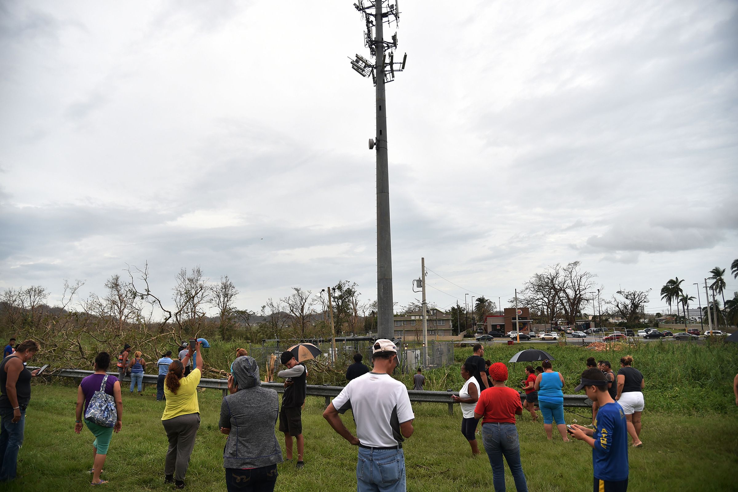 People cluster around a cell tower next to a highway in Dorado Puerto Rico after Hurricane Maria took out more than 90 percent of the island’s cell towers.