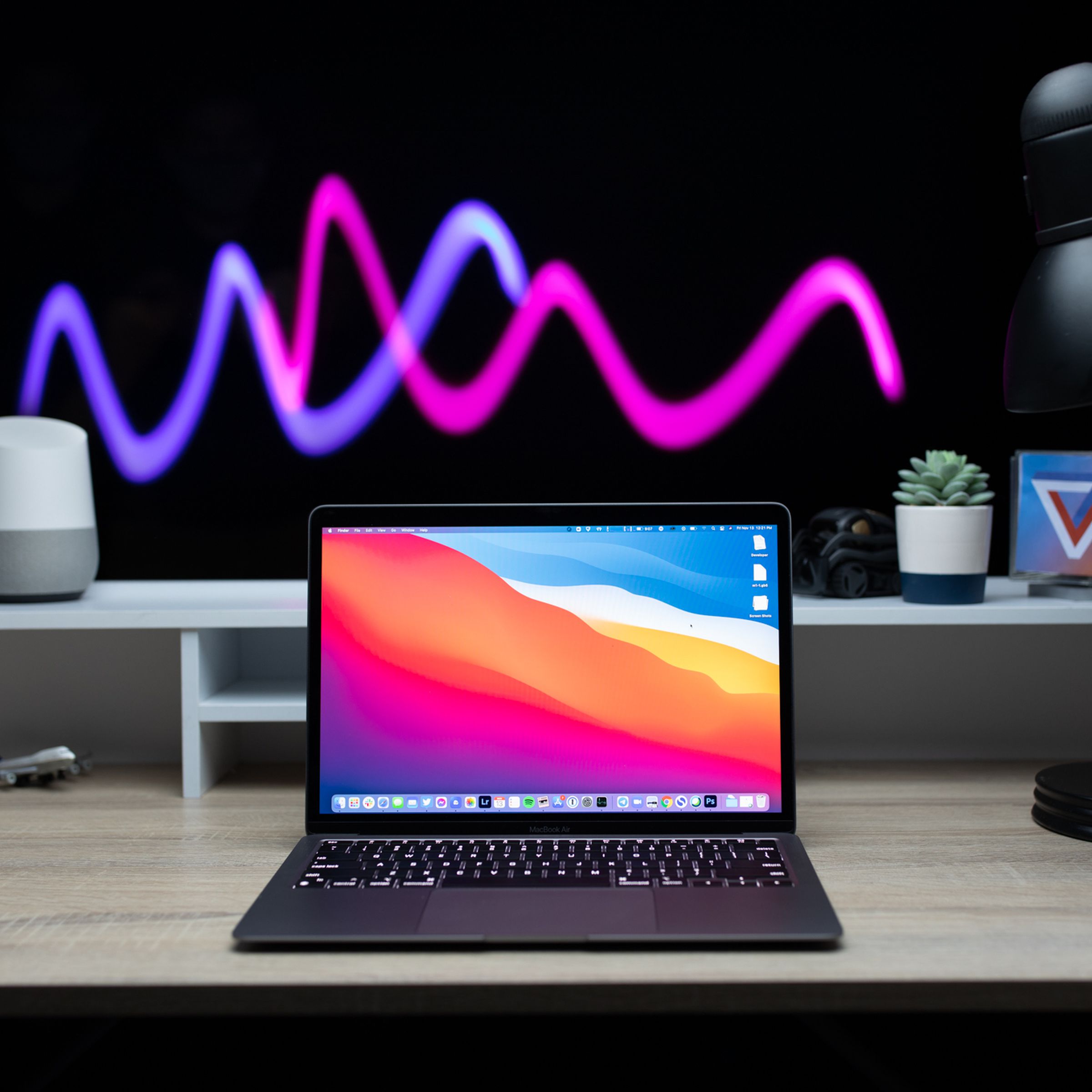 The 2020 M1 MacBook Air sitting on a desk with a long-exposure light effect happening in the background.