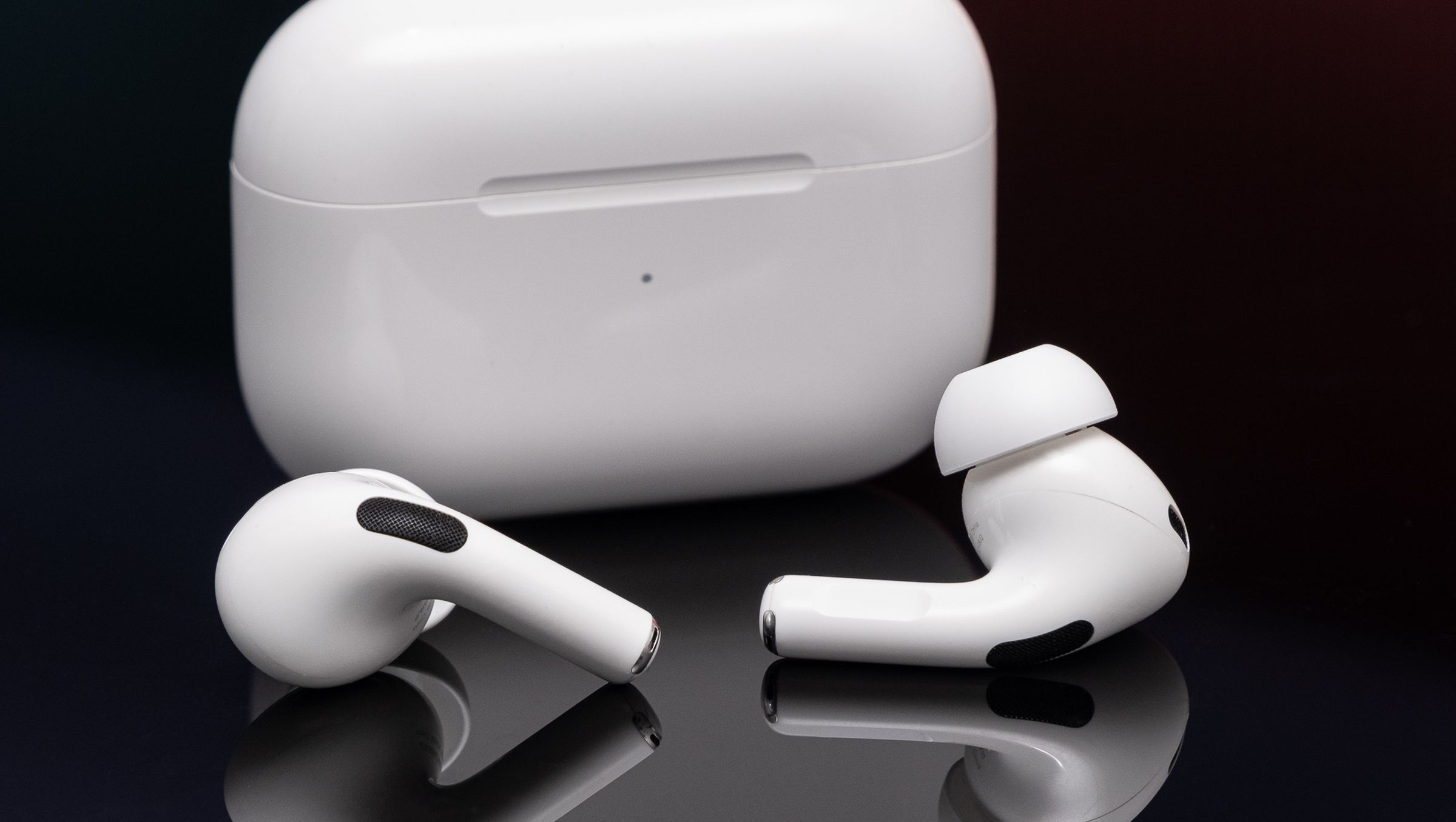 Apple’s second-generation AirPods Pro photographed on a reflective black surface.