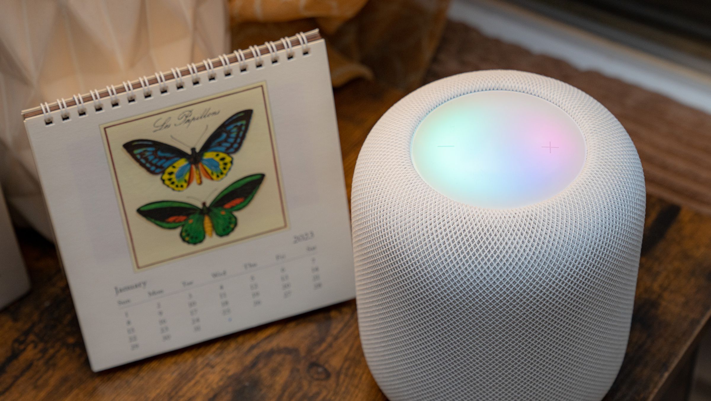 A photo of Apple’s second-generation HomePod with an illuminated touch surface.