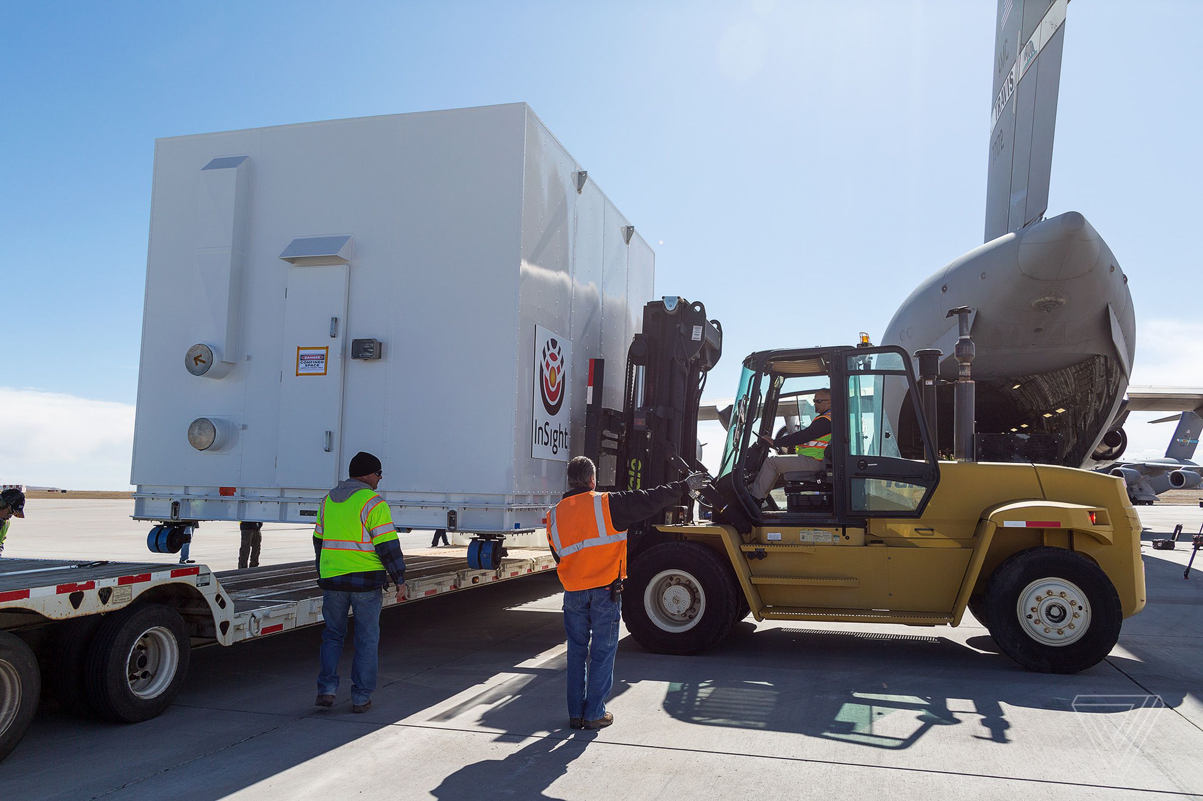 A forklift is used to move InSight’s container onto the ground