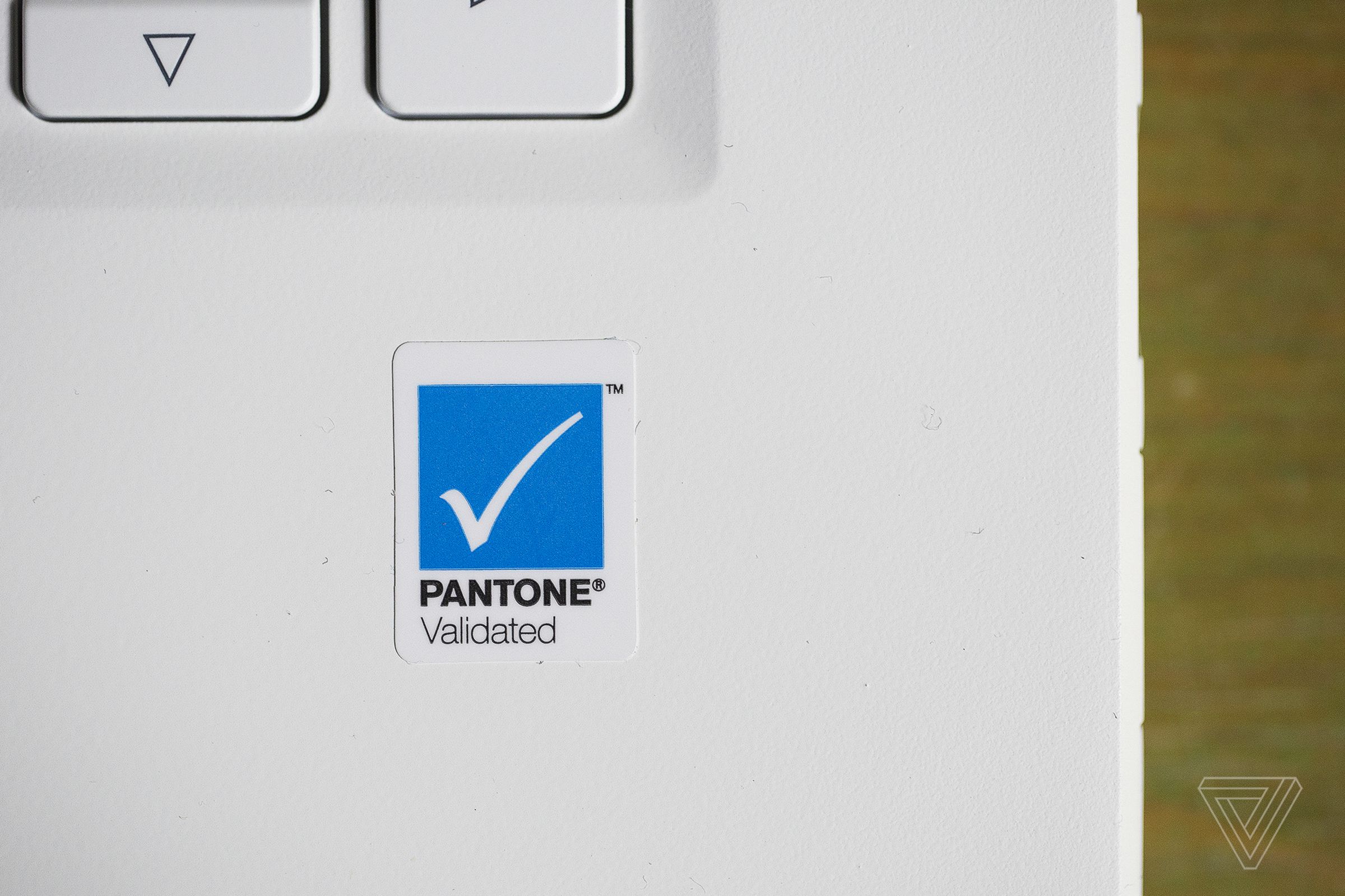 A sticker with a white checkmark on a blue background labeled “Pantone Validated” on the bottom right palm rest of the Acer ConceptD 7 Ezel.