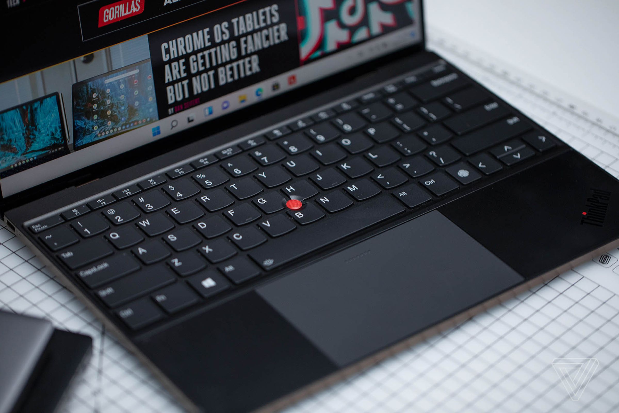 The ThinkPad Z13 keyboard seen from above and to the left. The screen displays The Verge homepage.