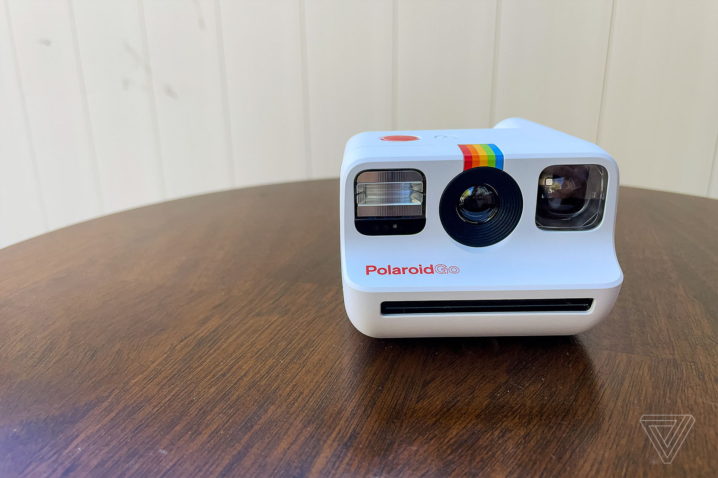 The front of the white Polaroid Go resting on a table.