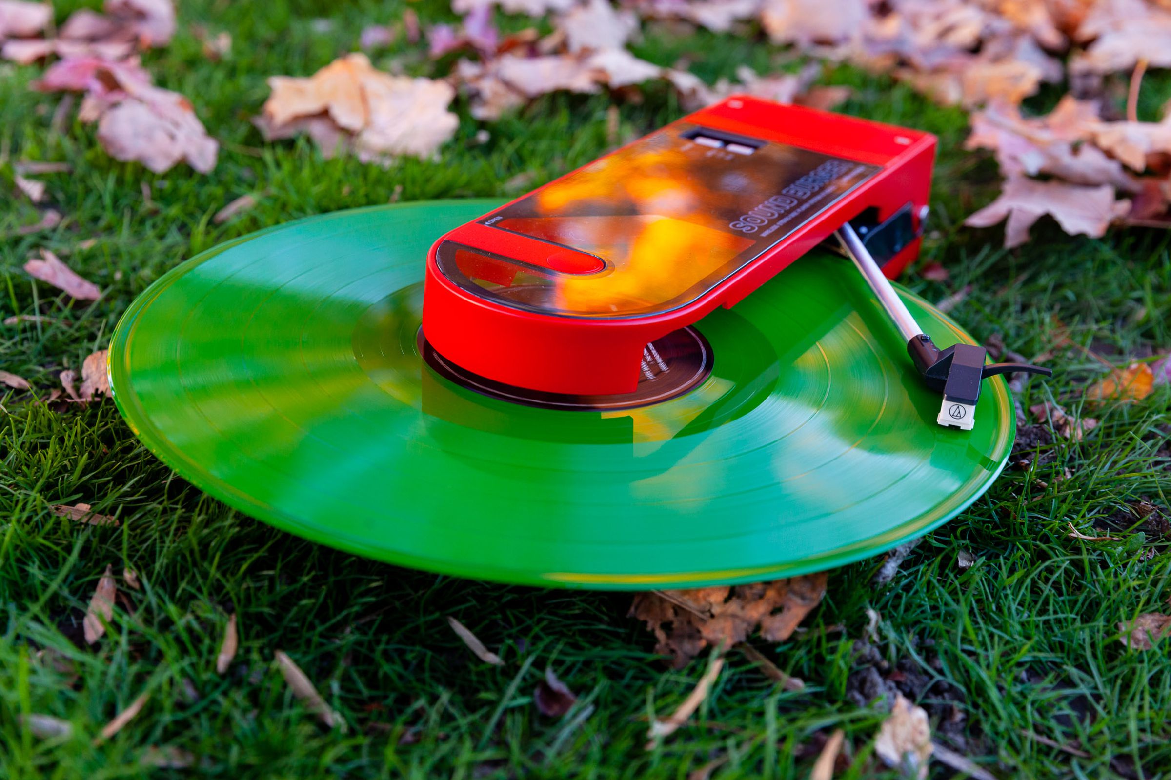 The Sound Burger from the front playing a green record on grass.